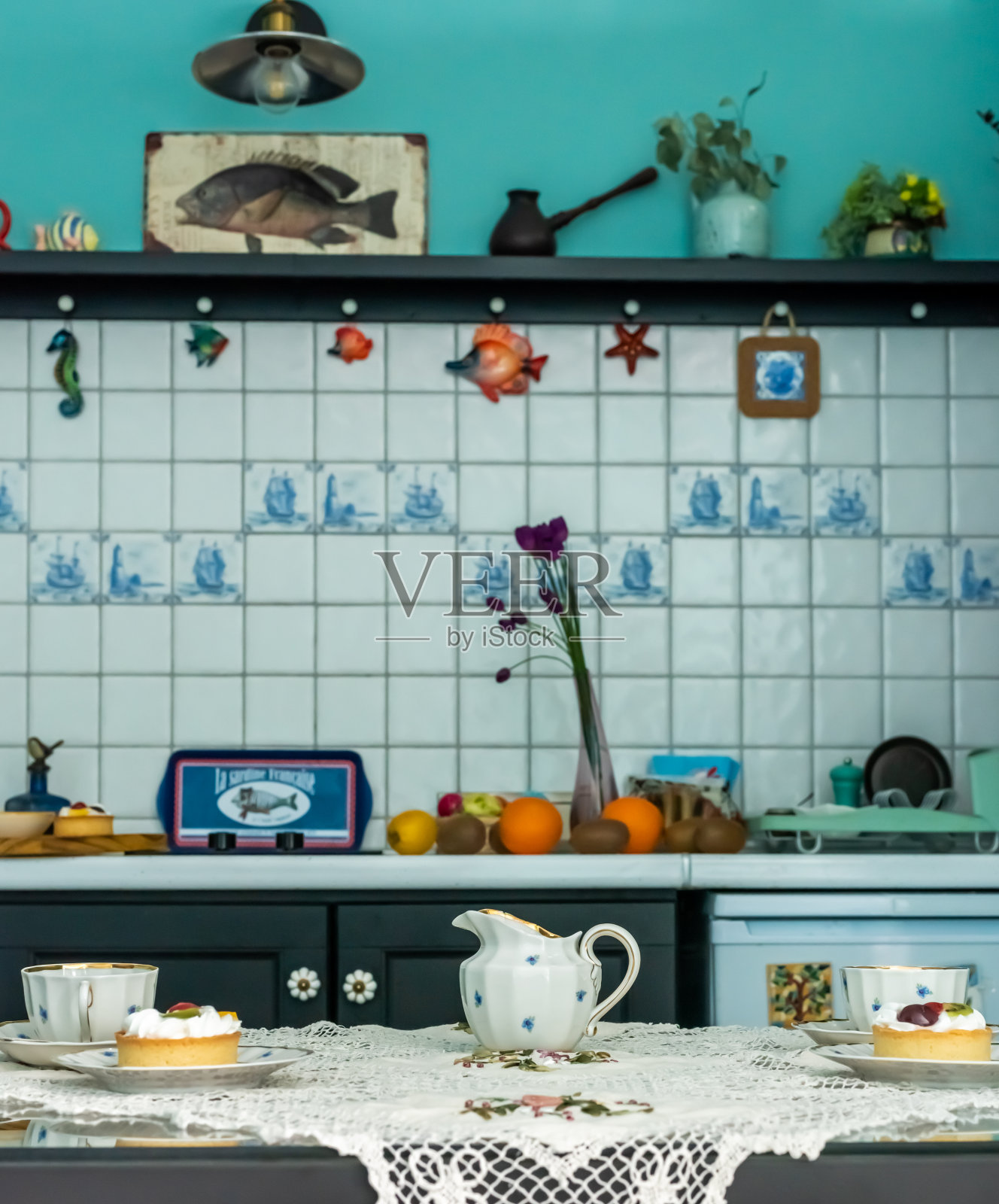 桌上铺着桌布，有杯子、茶托和蛋糕。照片摄影图片