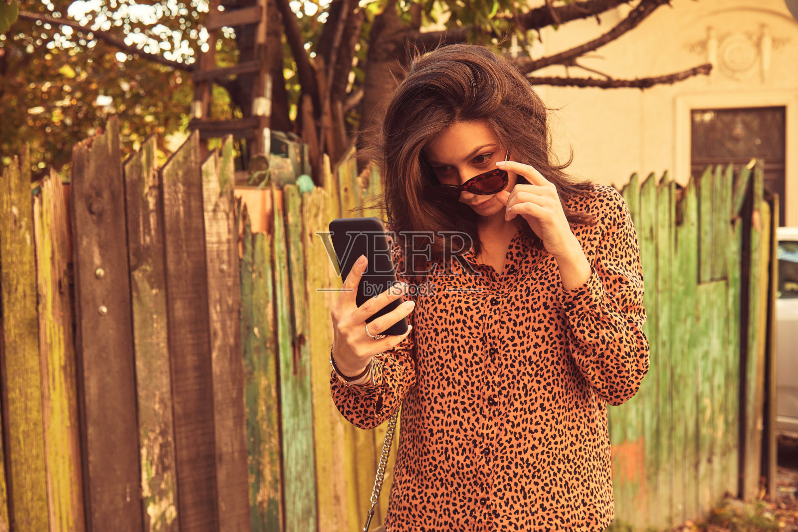 漂亮时髦的女人在街上用手机。照片摄影图片