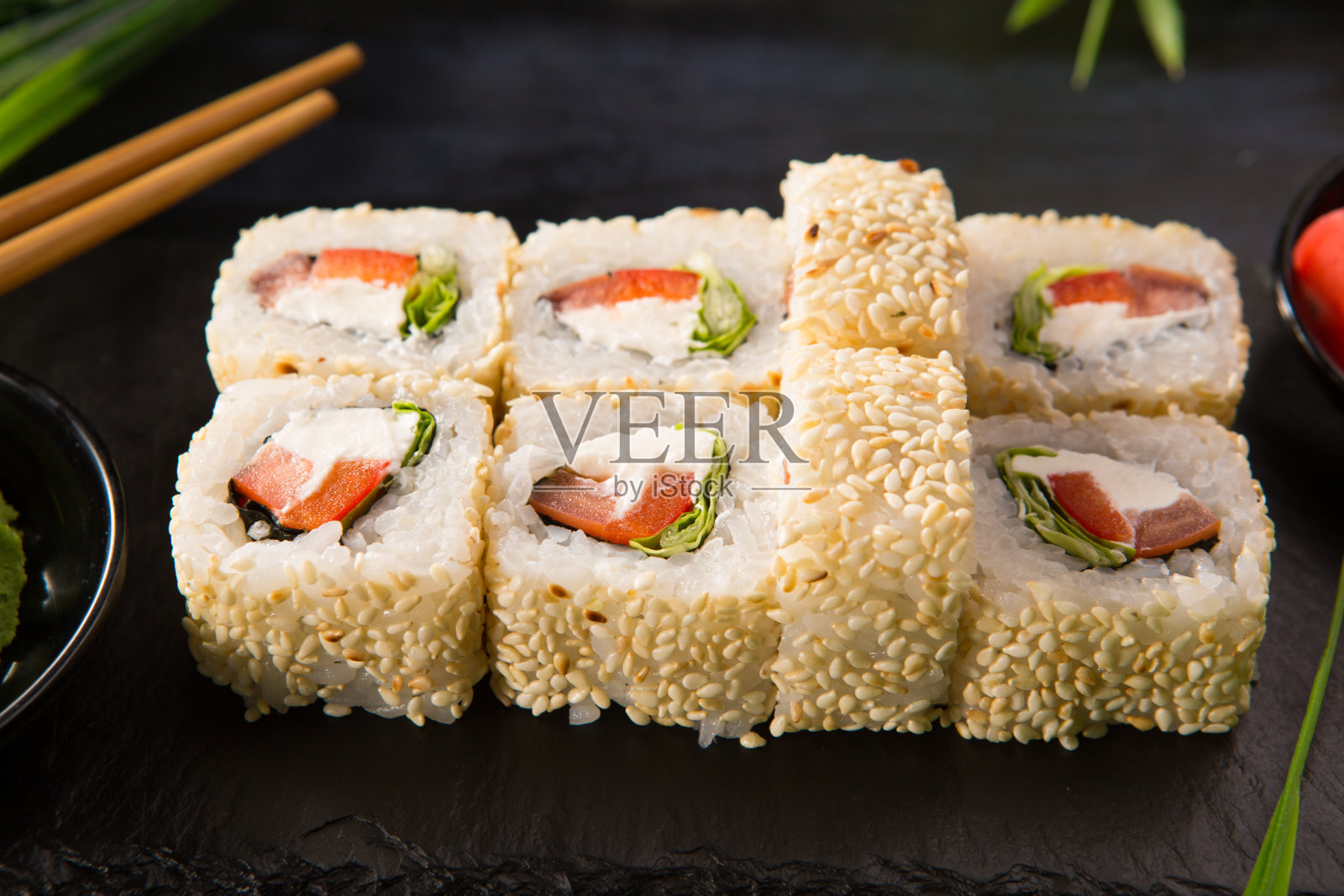 一套寿司卷与芥末和生姜在黑色的背景。日本东方美食照片摄影图片