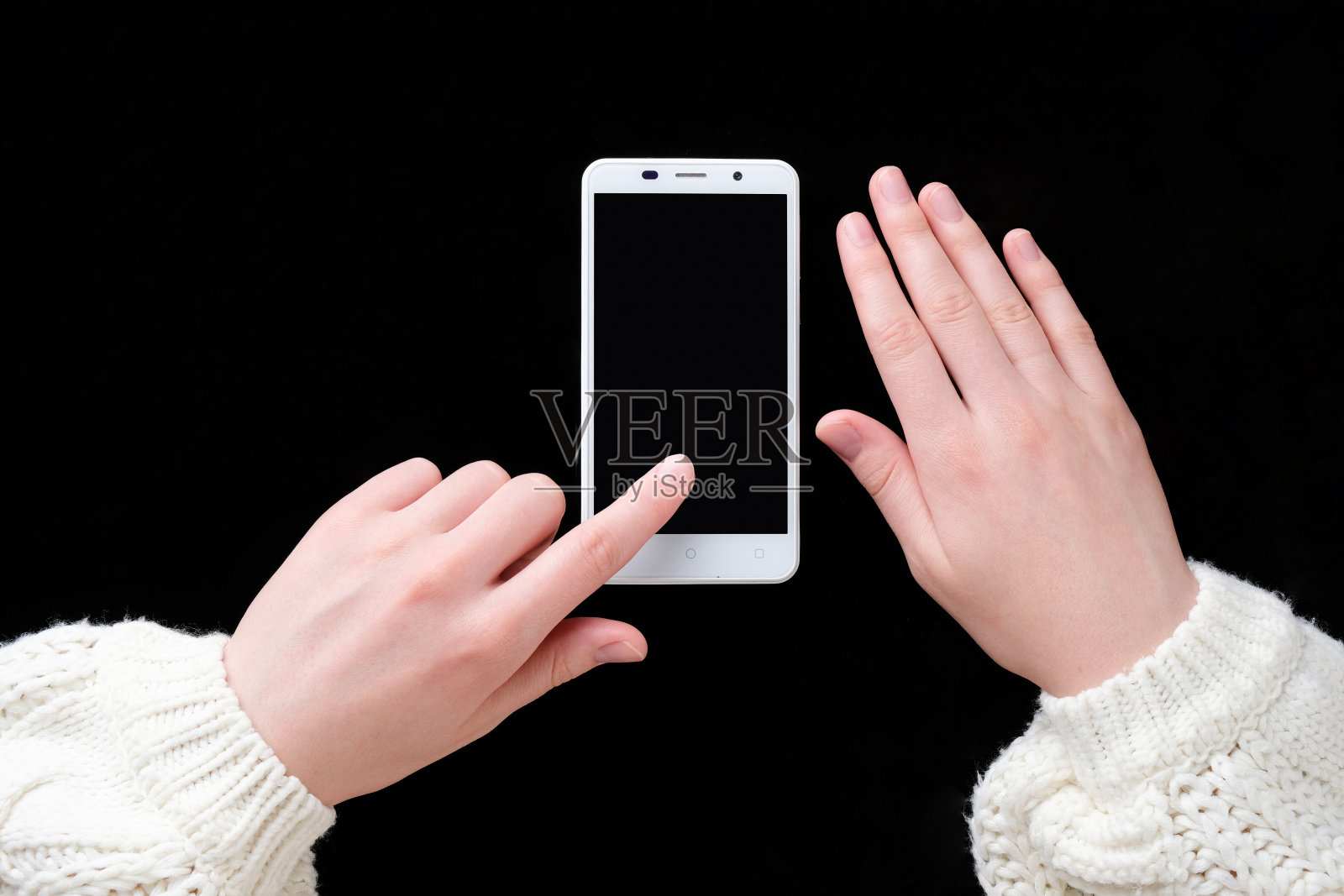 手拿着电话放在桌子上。一个女人手里拿着一个电话。照片摄影图片