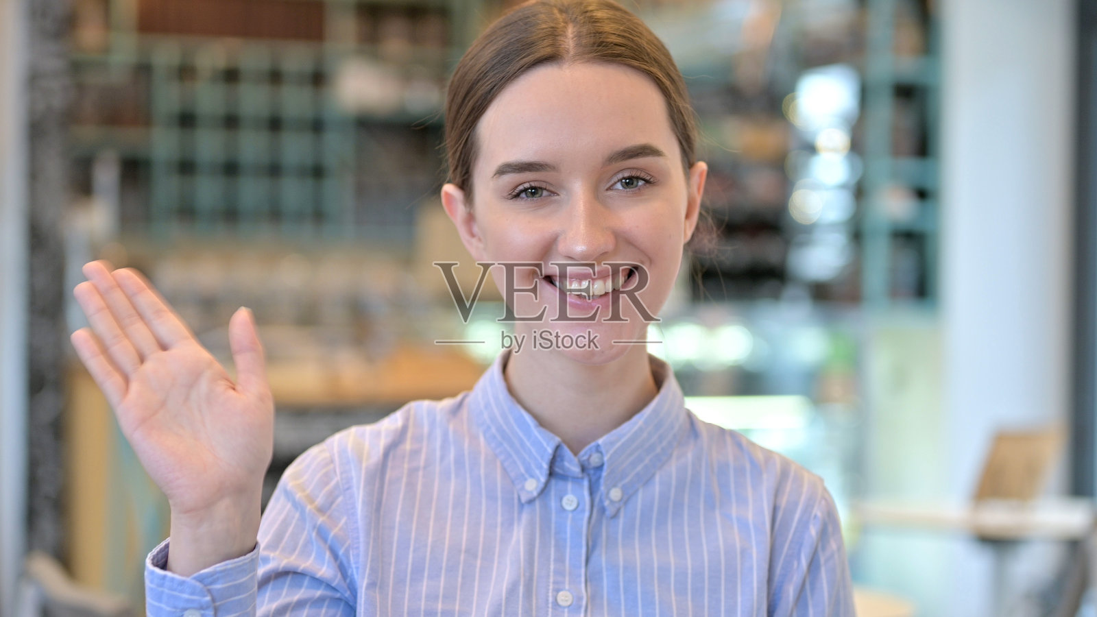 年轻女子在镜头前挥手的肖像照片摄影图片