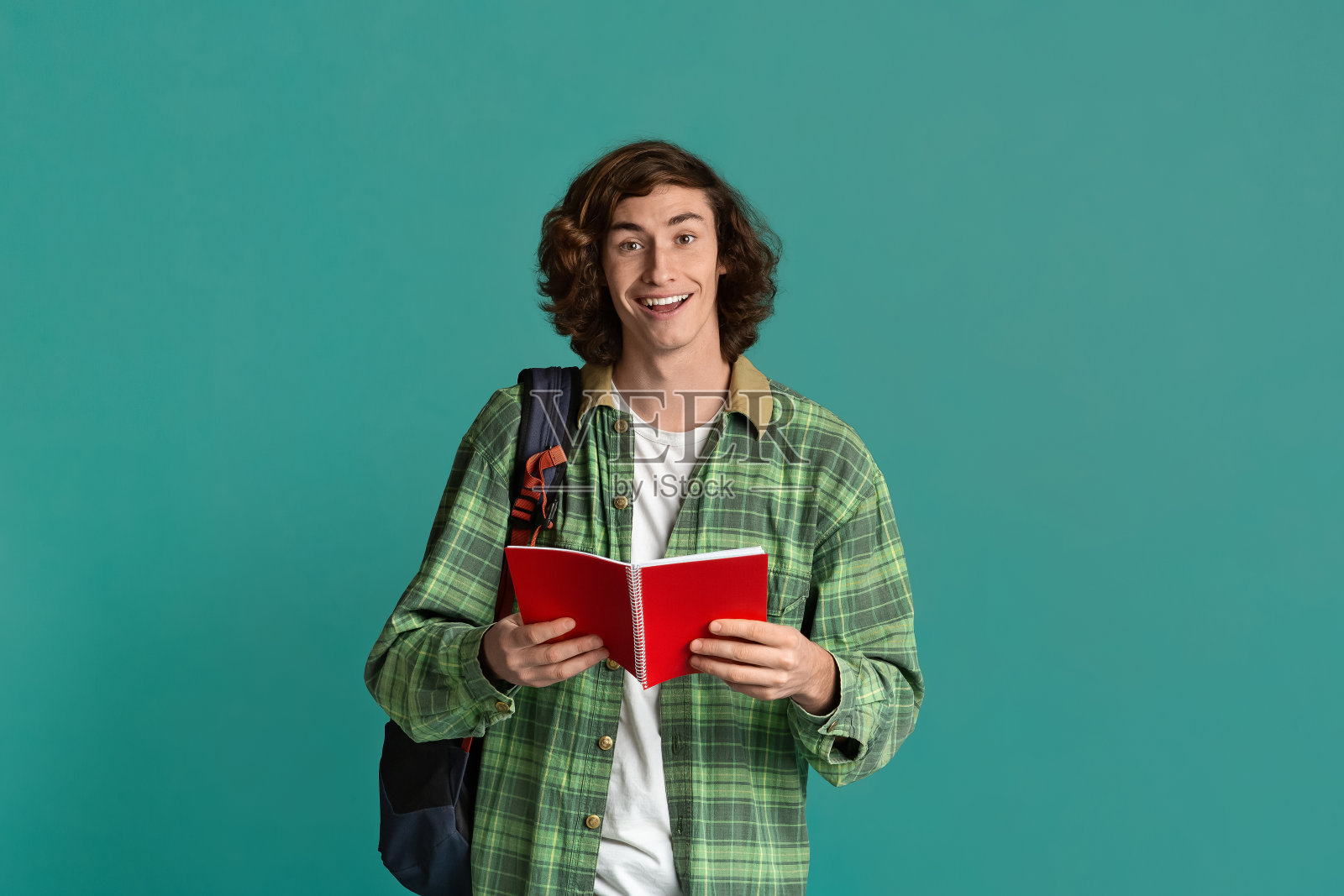 回到学校。快乐的学生与打开笔记本和背包在绿松石背景照片摄影图片