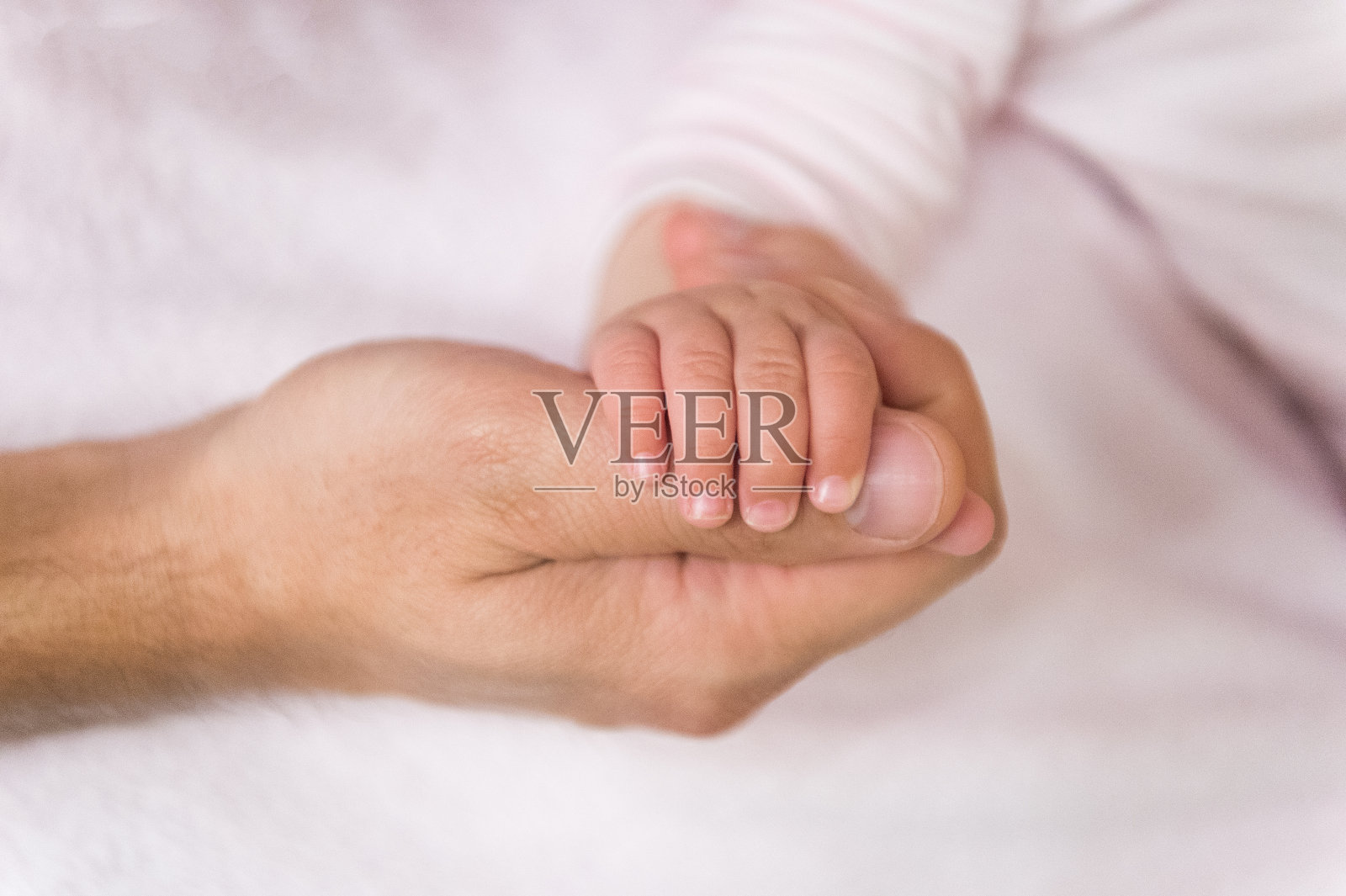 婴儿手握男人手指照片摄影图片