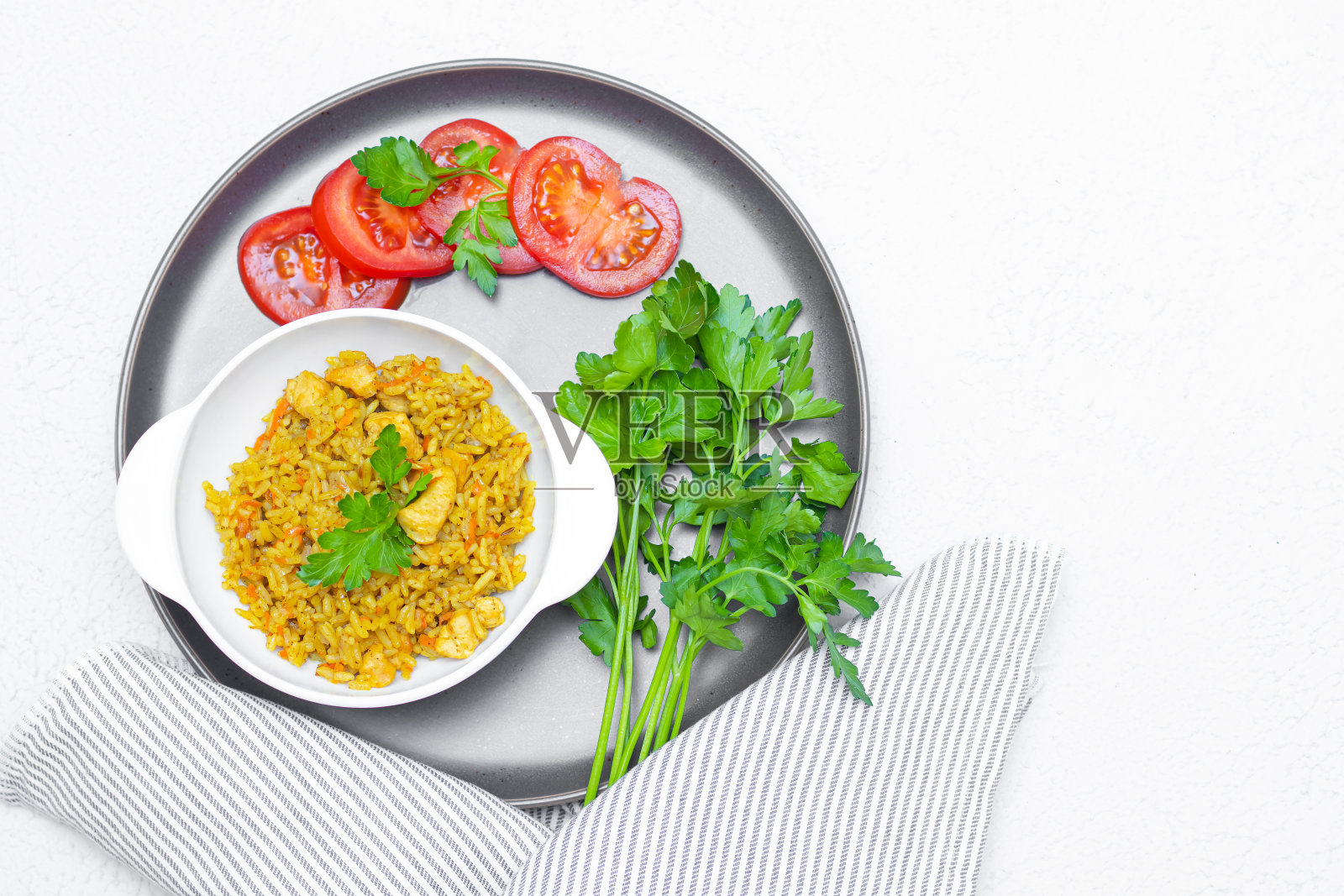 盘子里的肉饭。为菜单拍摄概念。餐厅的招牌菜。辣的食物。大米食物。东方菜肴。白盘子里的肉饭，背景很淡。照片摄影图片