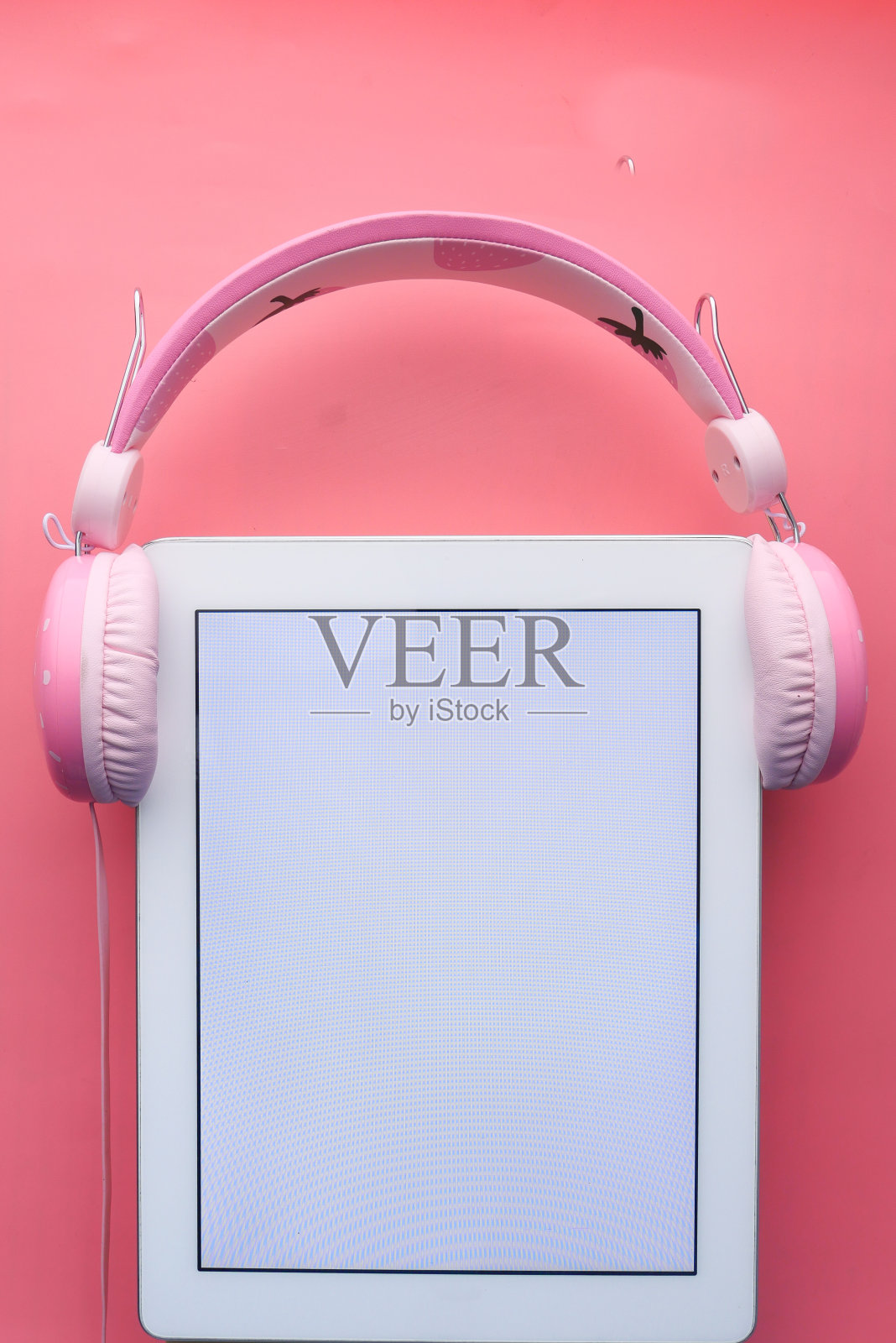 粉色背景的数码平板电脑和耳机照片摄影图片