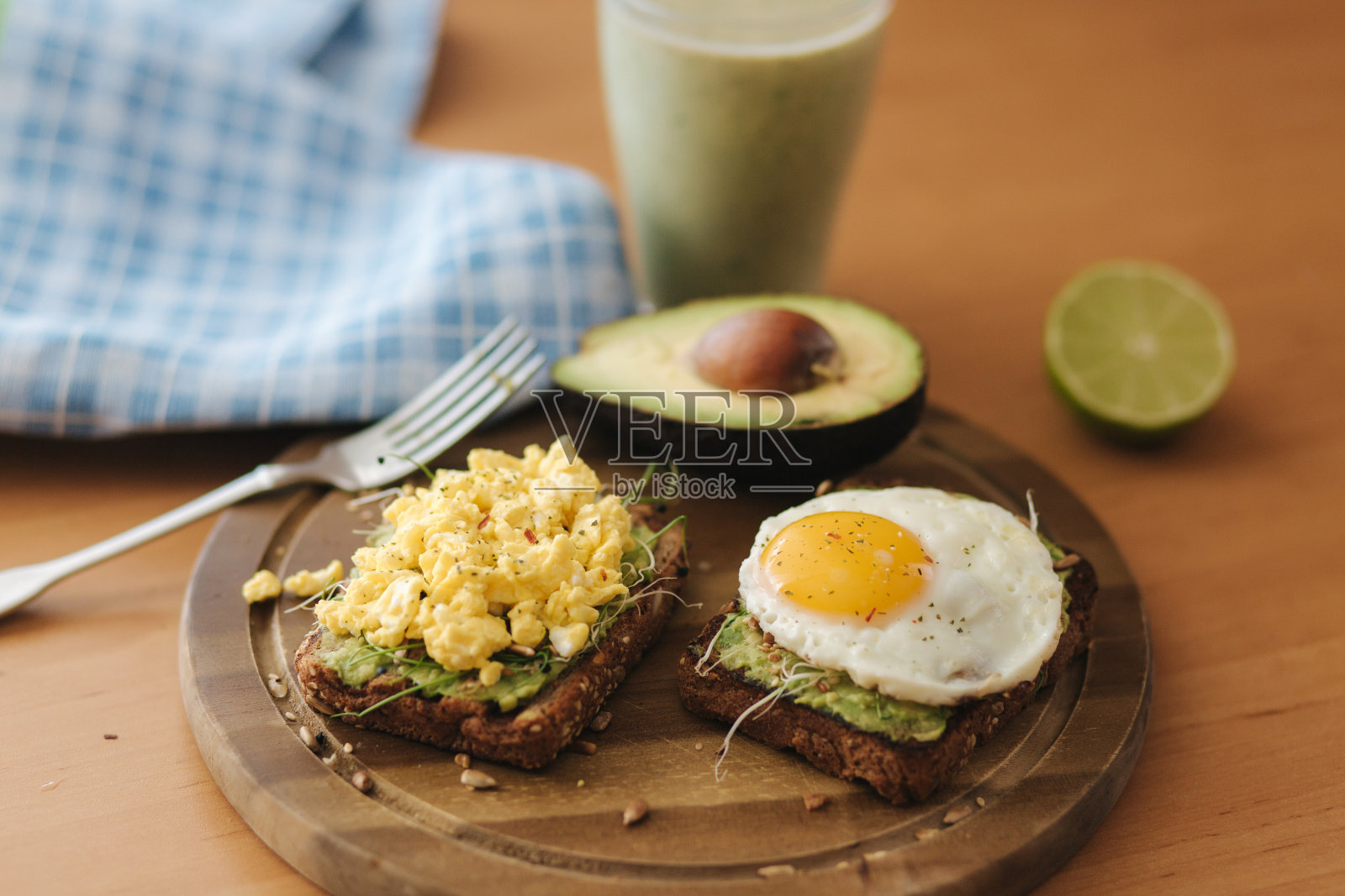 不同的牛油果鸡蛋三明治和全麦面包放在木板上。奶昔和菠菜照片摄影图片