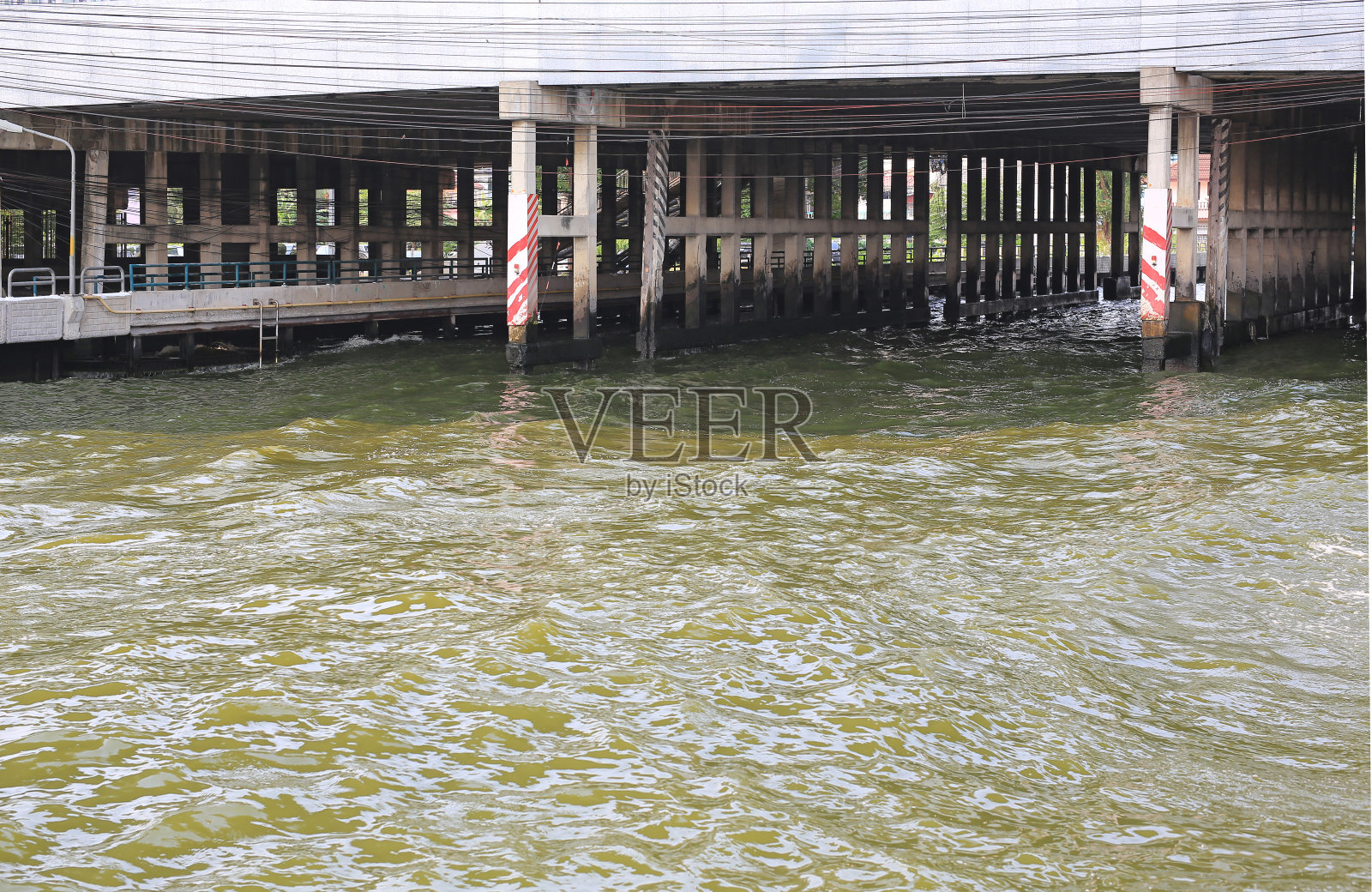 运河里的污水和混凝土桥柱。照片摄影图片