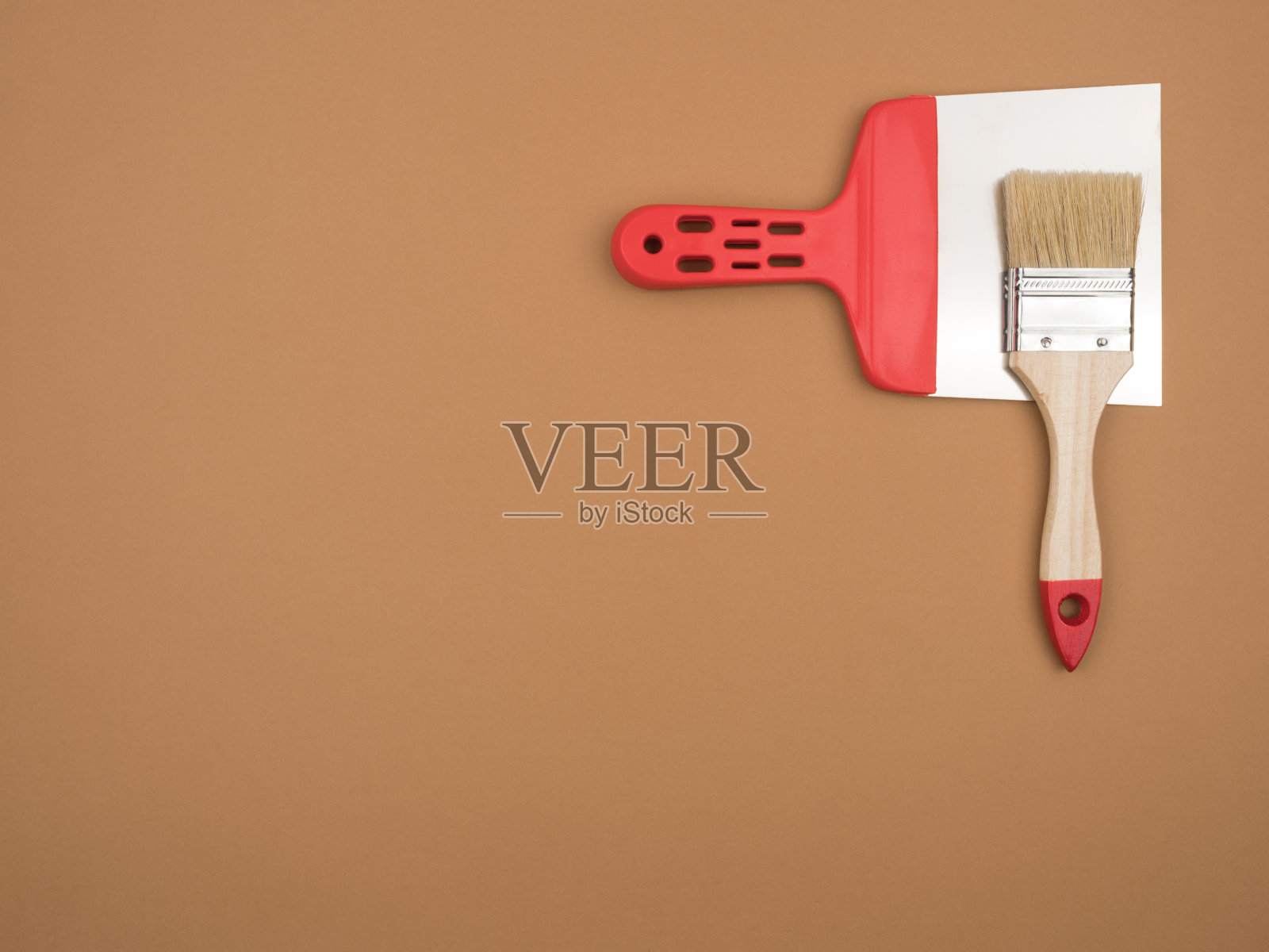 米色背景上的施工工具。画笔和调色刀。照片摄影图片