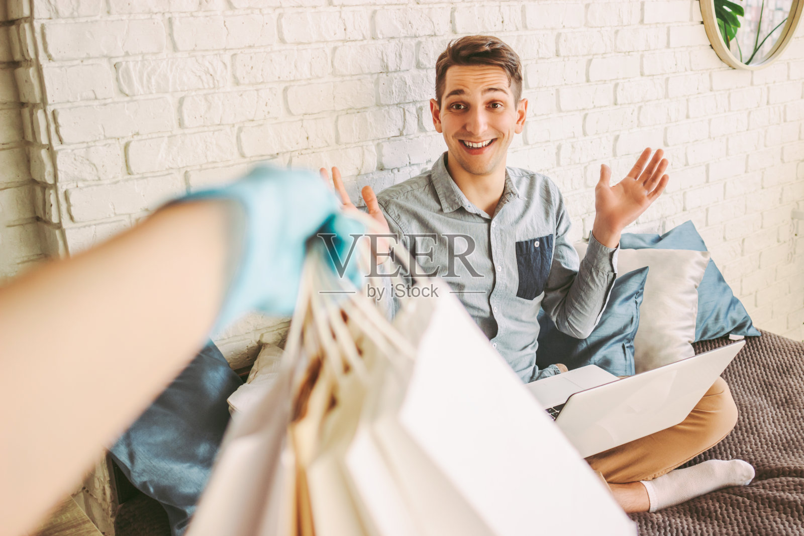 快乐的潮男从快递员那里收到购物袋照片摄影图片