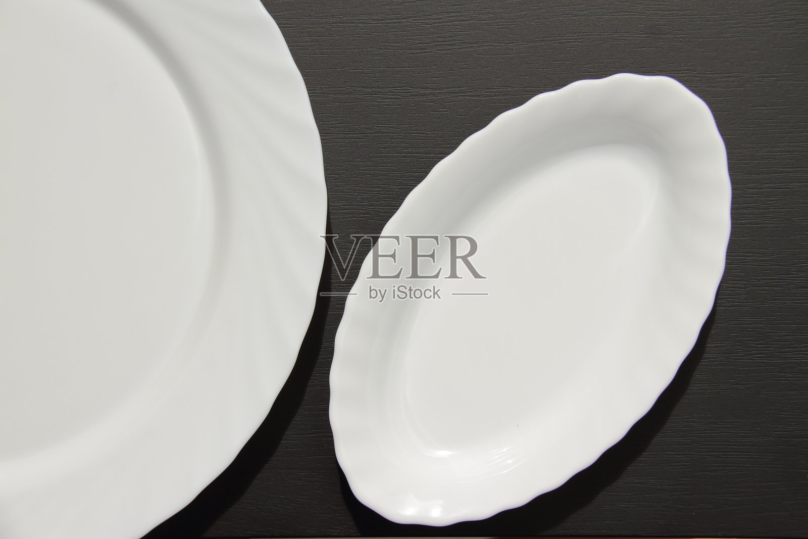 白色陶瓷长板上黑色哑光木桌，俯视图，放置文字照片摄影图片