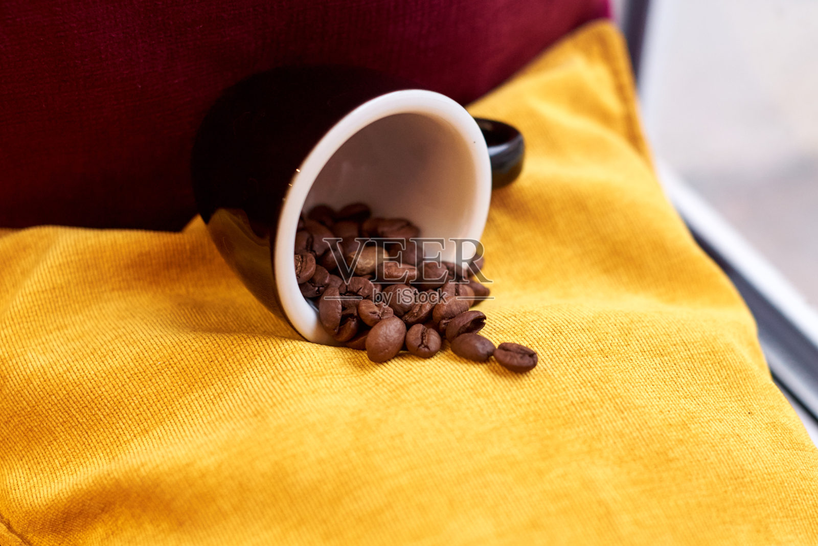 白色杯子里的咖啡豆在黄色的背景下烘烤照片摄影图片