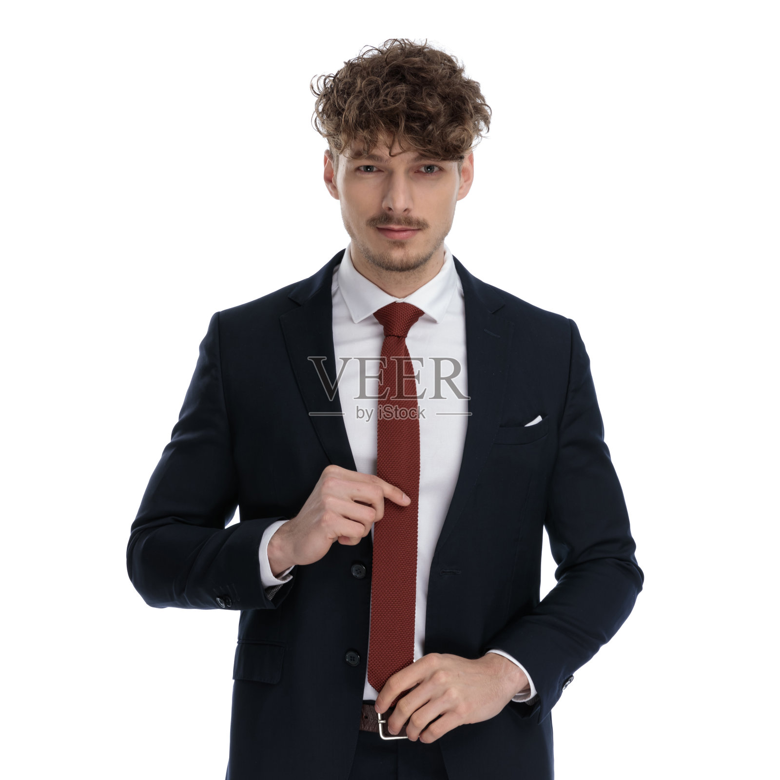 迷人的商人一边站着一边调整领带照片摄影图片