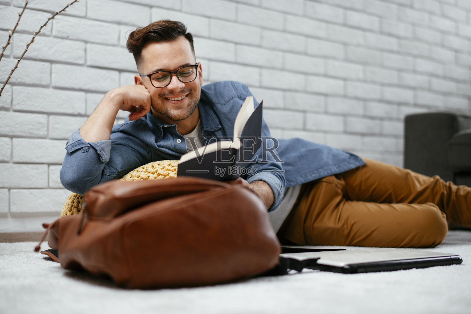 一个在客厅看书的普通人。照片摄影图片