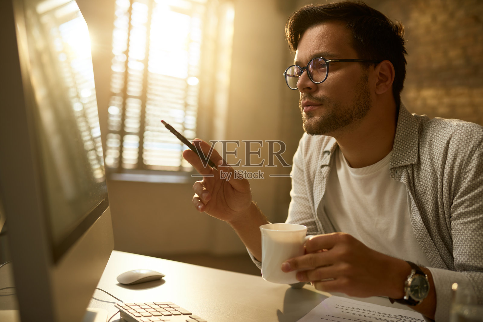 年轻的企业家在办公室的台式电脑上分析计划。照片摄影图片