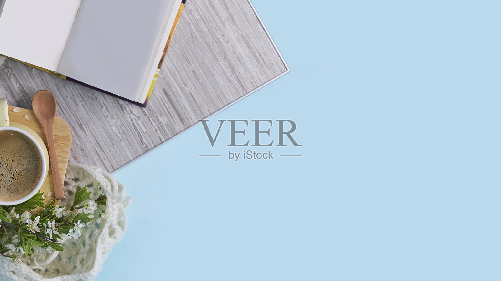 温馨的家居静物:一杯热咖啡，春天的鲜花和打开的书与温暖的格子。春季概念，免费拷贝空间。近视图照片摄影图片