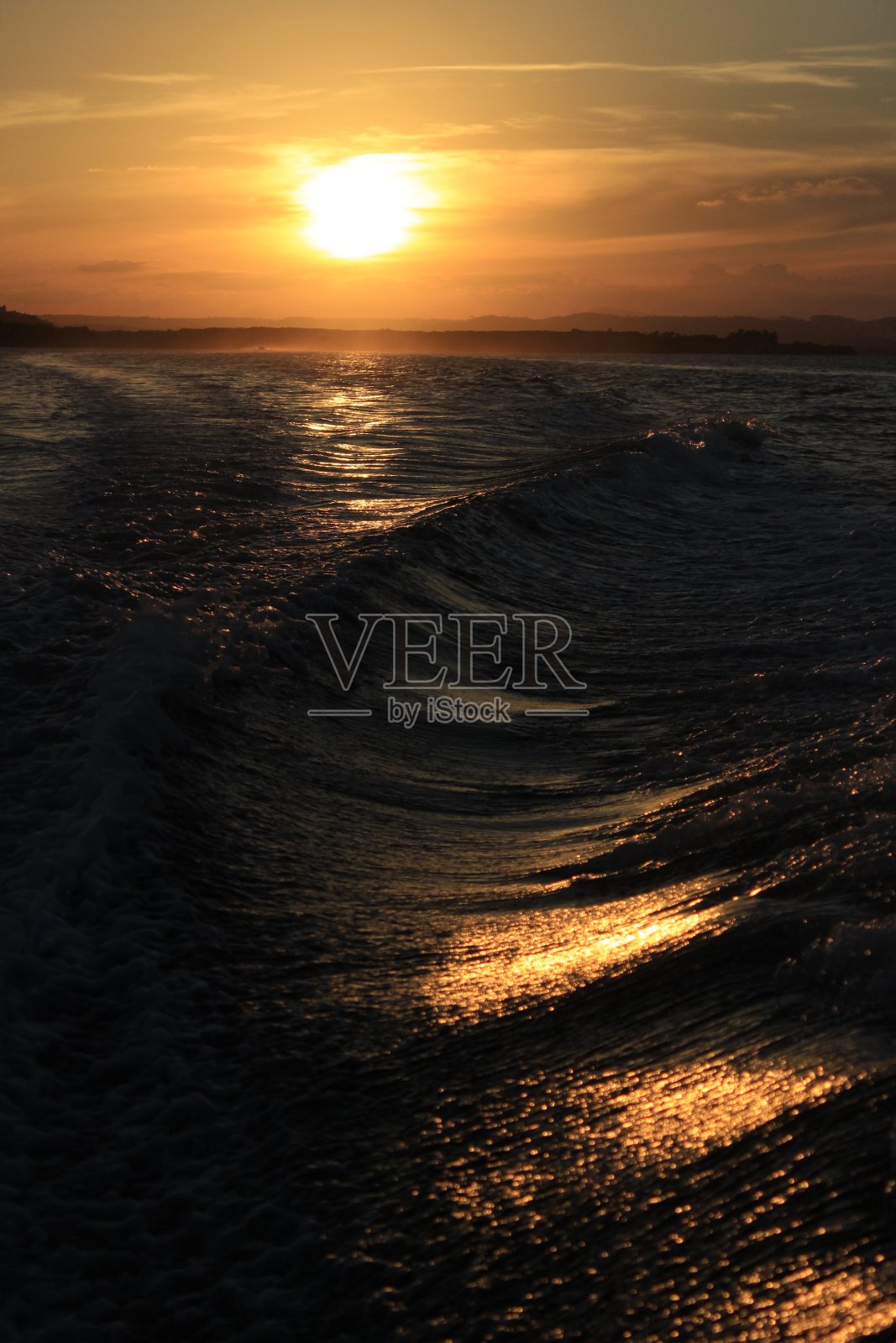 日落或日出时海浪和云彩中的太阳反射照片摄影图片