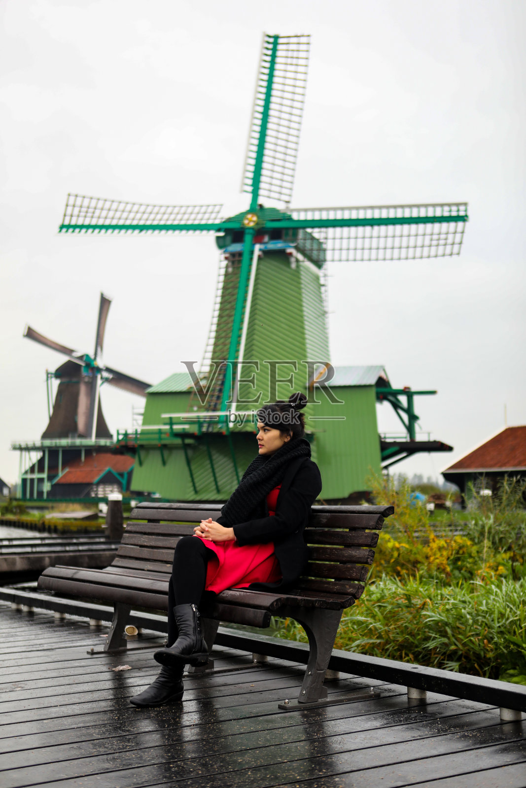 亚洲年轻女子享受与她的假期与风车背景在阿姆斯特丹照片摄影图片