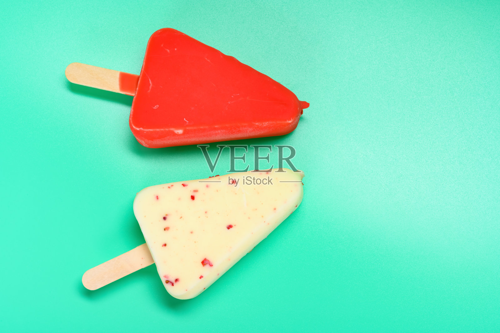 红色和白色的巧克力外棒冰在绿色的背景与复制空间照片摄影图片