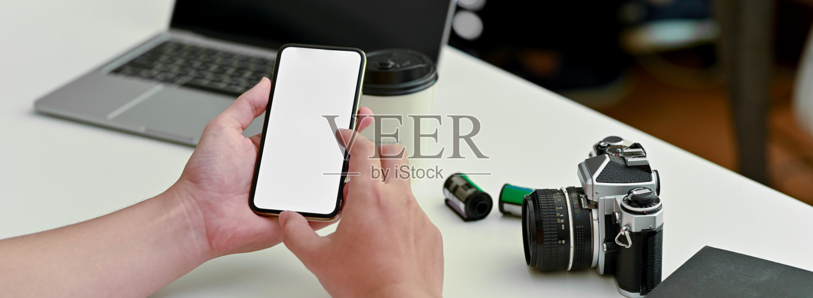 近距离观看摄影师使用空白屏幕智能手机在工作空间照片摄影图片