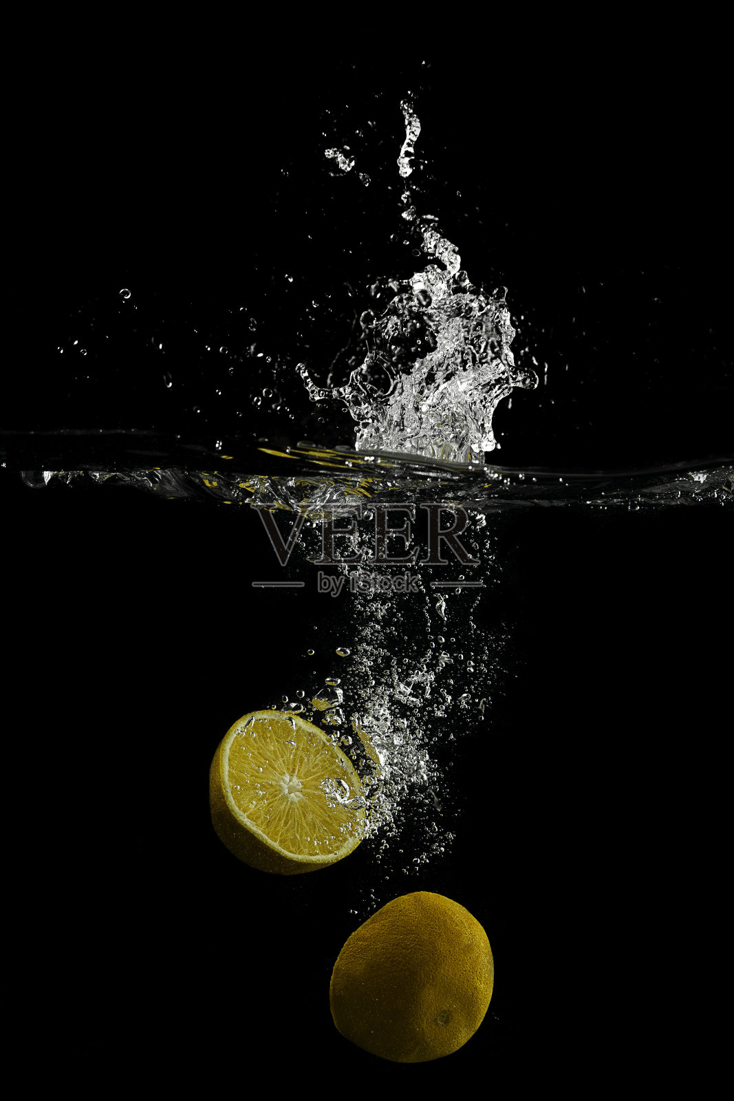 将柠檬切片放入水中溅起水花照片摄影图片