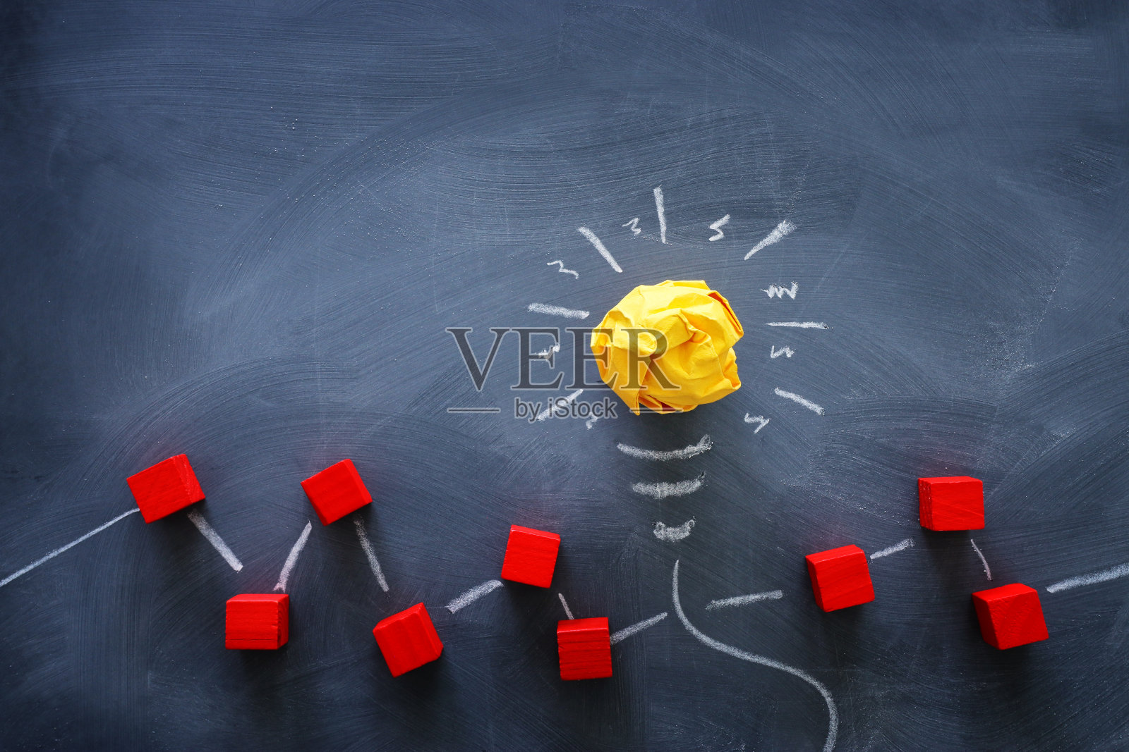 教育理念的形象。创意和创新。在黑板上，皱巴巴的纸就像灯泡一样照片摄影图片