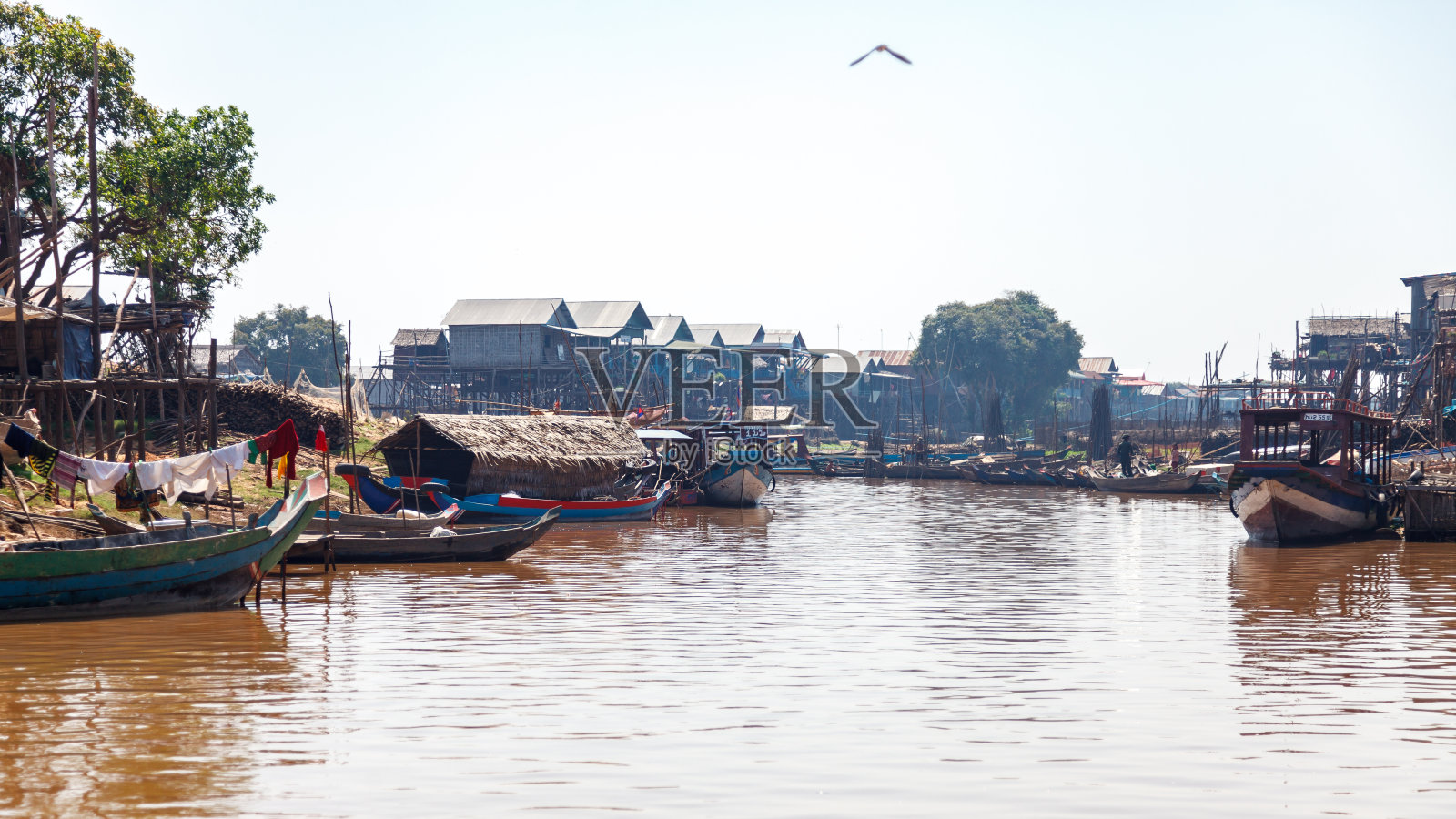 柬埔寨洞里萨河- 2014年2月:甘榜弗卢克村干旱季节。柬埔寨暹粒附近一个水上村庄居民的生活和工作照片摄影图片
