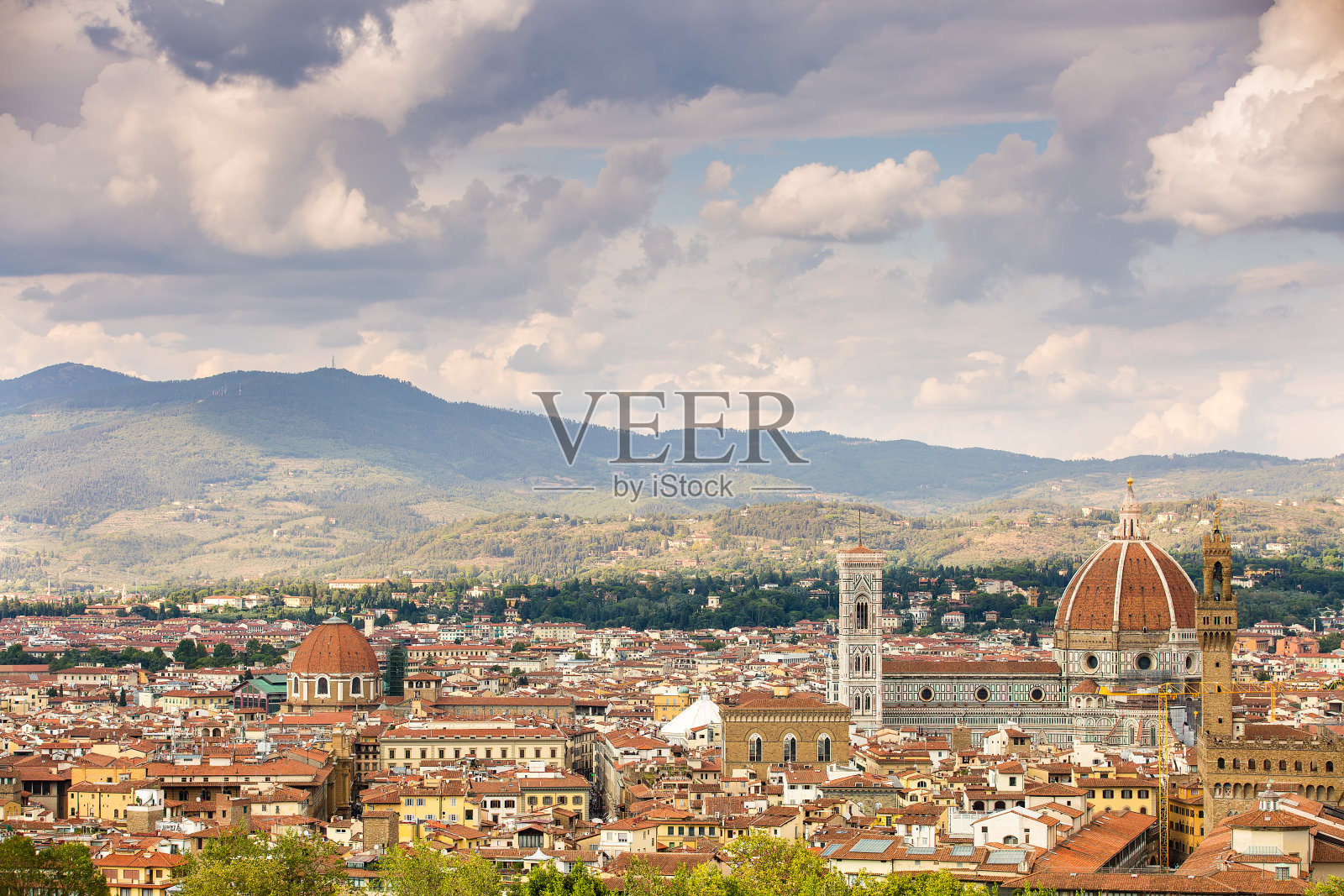 佛罗伦萨。意大利托斯卡纳。鲜花圣玛丽大教堂(圣玛丽亚德尔菲奥雷大教堂)正面的美丽景色，以及最近住宅的瓦制屋顶照片摄影图片
