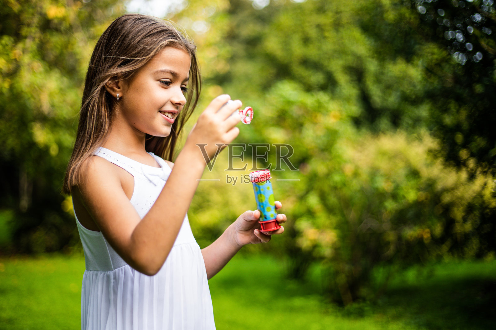 可爱的小女孩在大自然中玩肥皂泡照片摄影图片