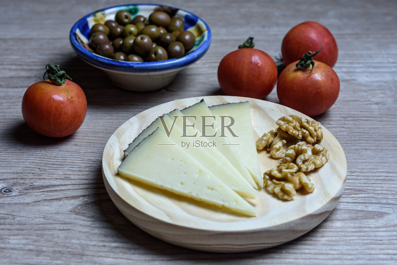这是典型的西班牙小吃，陈年曼彻格奶酪和橄榄放在木制的灰色桌子上照片摄影图片