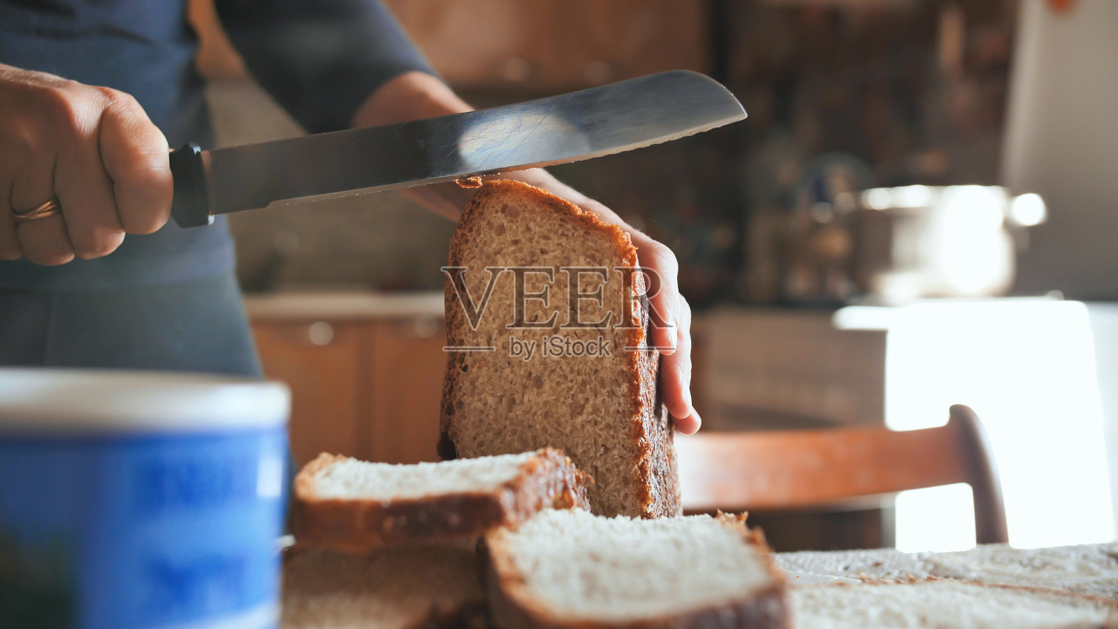 烹饪早餐。一个年轻的女人切面包照片摄影图片