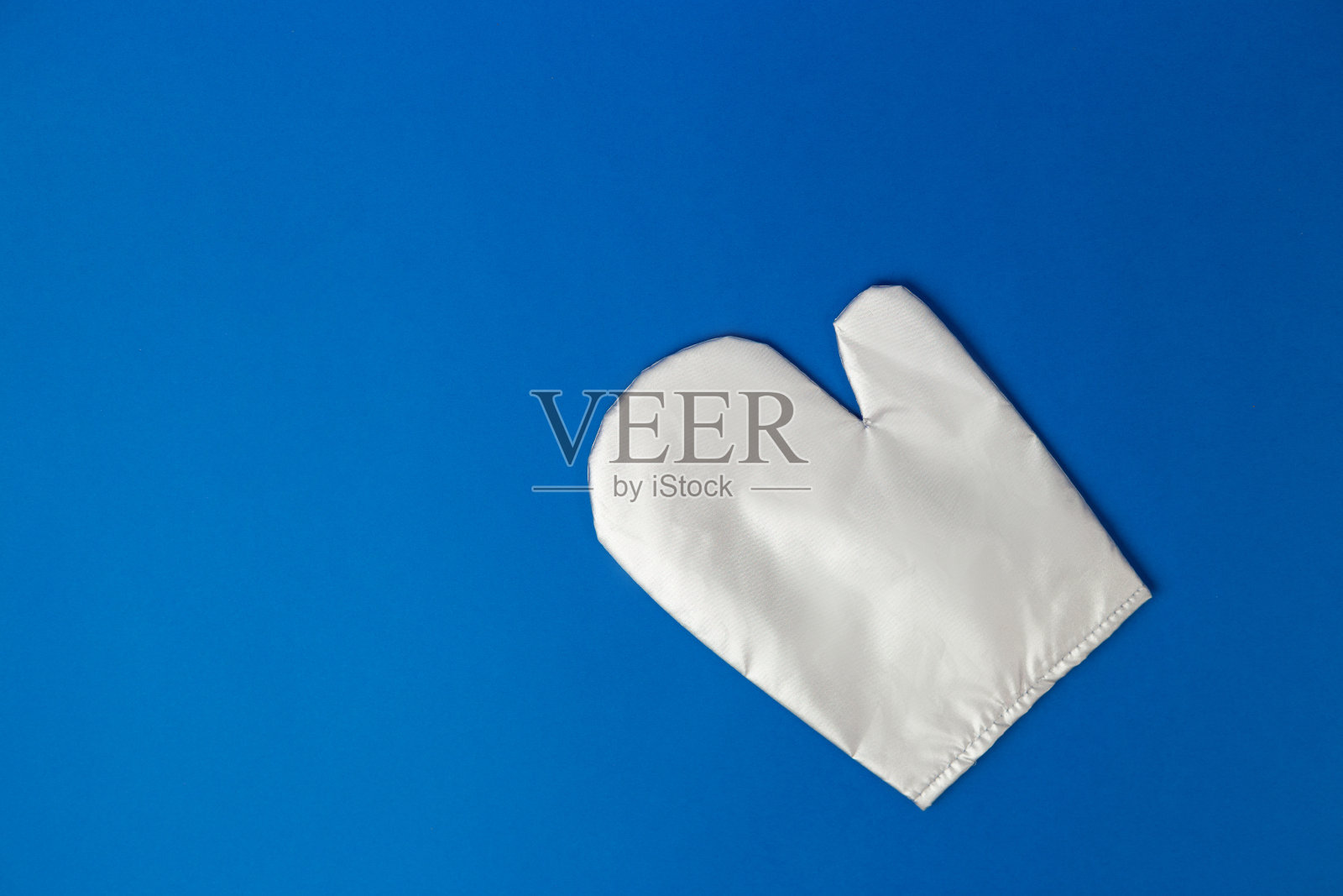 厨房银色手套上的蓝色背景。平铺横幅，俯视图，拷贝空间，热保护和安全。烤箱手套和文本空间照片摄影图片