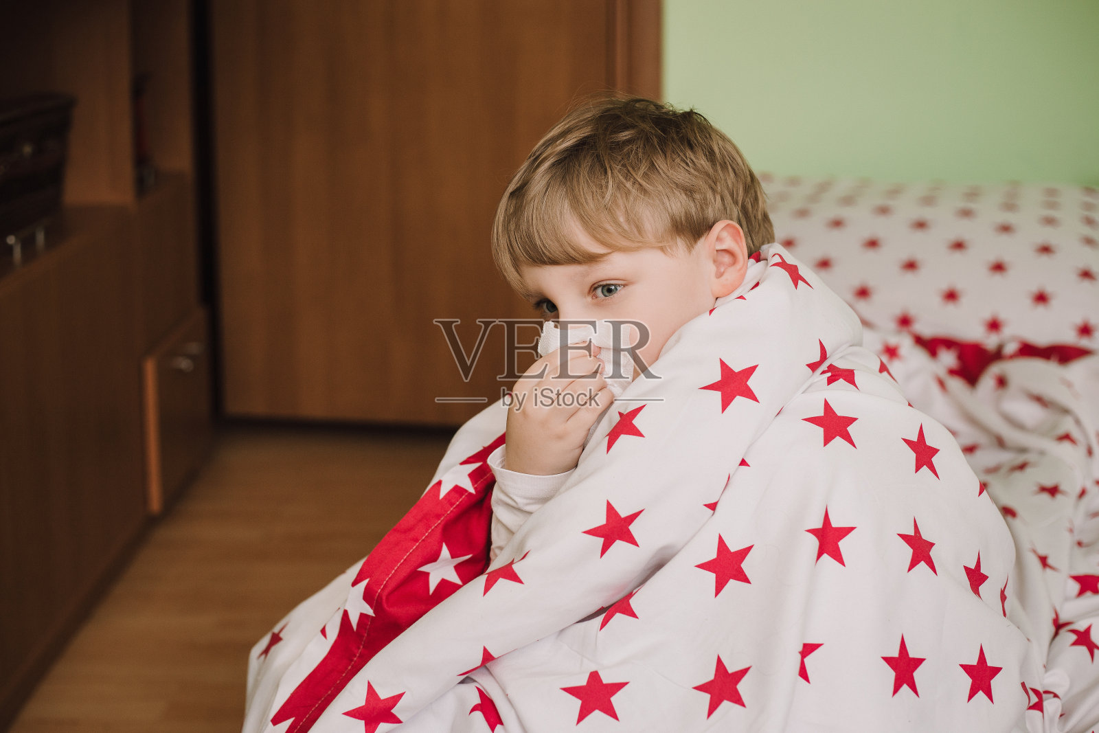 生病的男孩和女孩躺在家里的床上，盖着被子咳嗽。蹒跚学步的孩子患流感。普通感冒是一种细菌病毒的感染。冠状病毒照片摄影图片