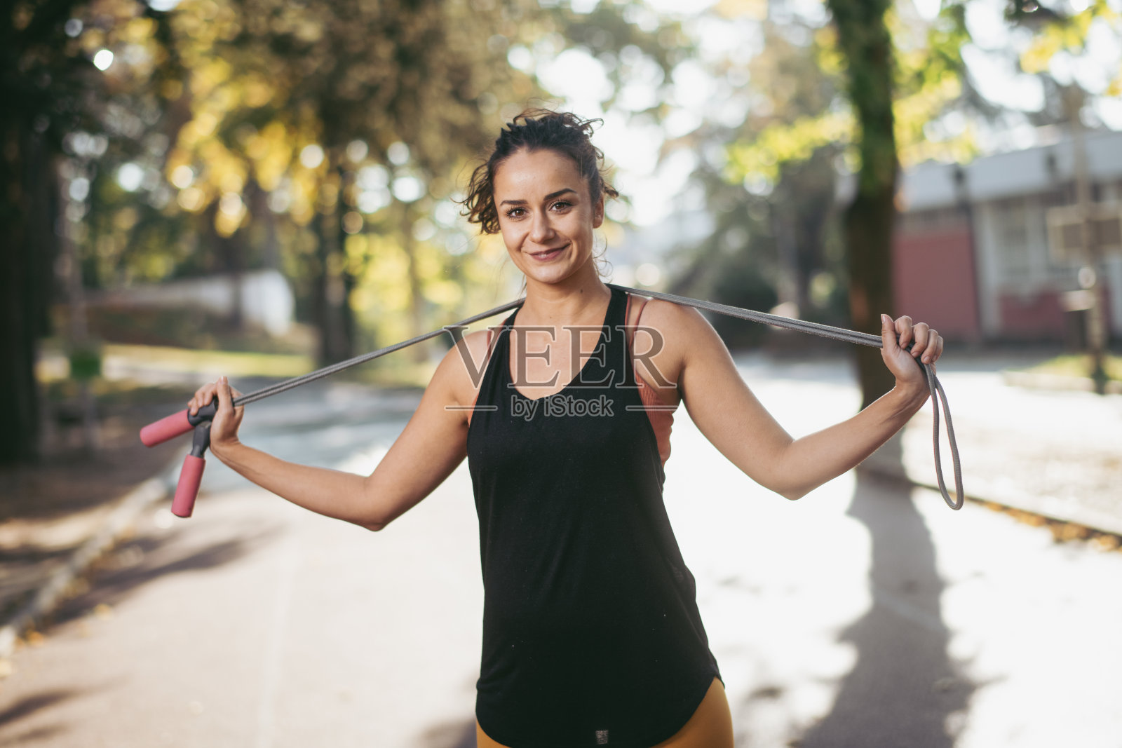 运动的年轻女子拿着跳绳照片摄影图片