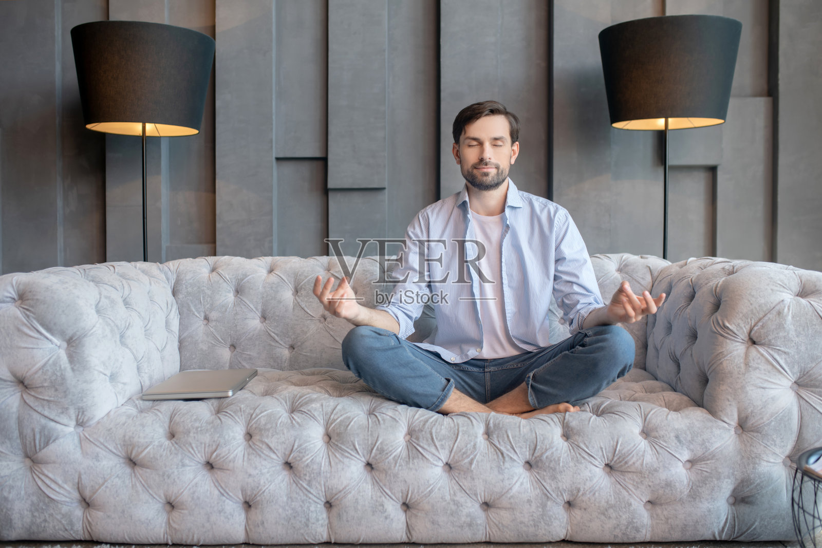 光脚男人闭着眼睛摆姿势坐着照片摄影图片