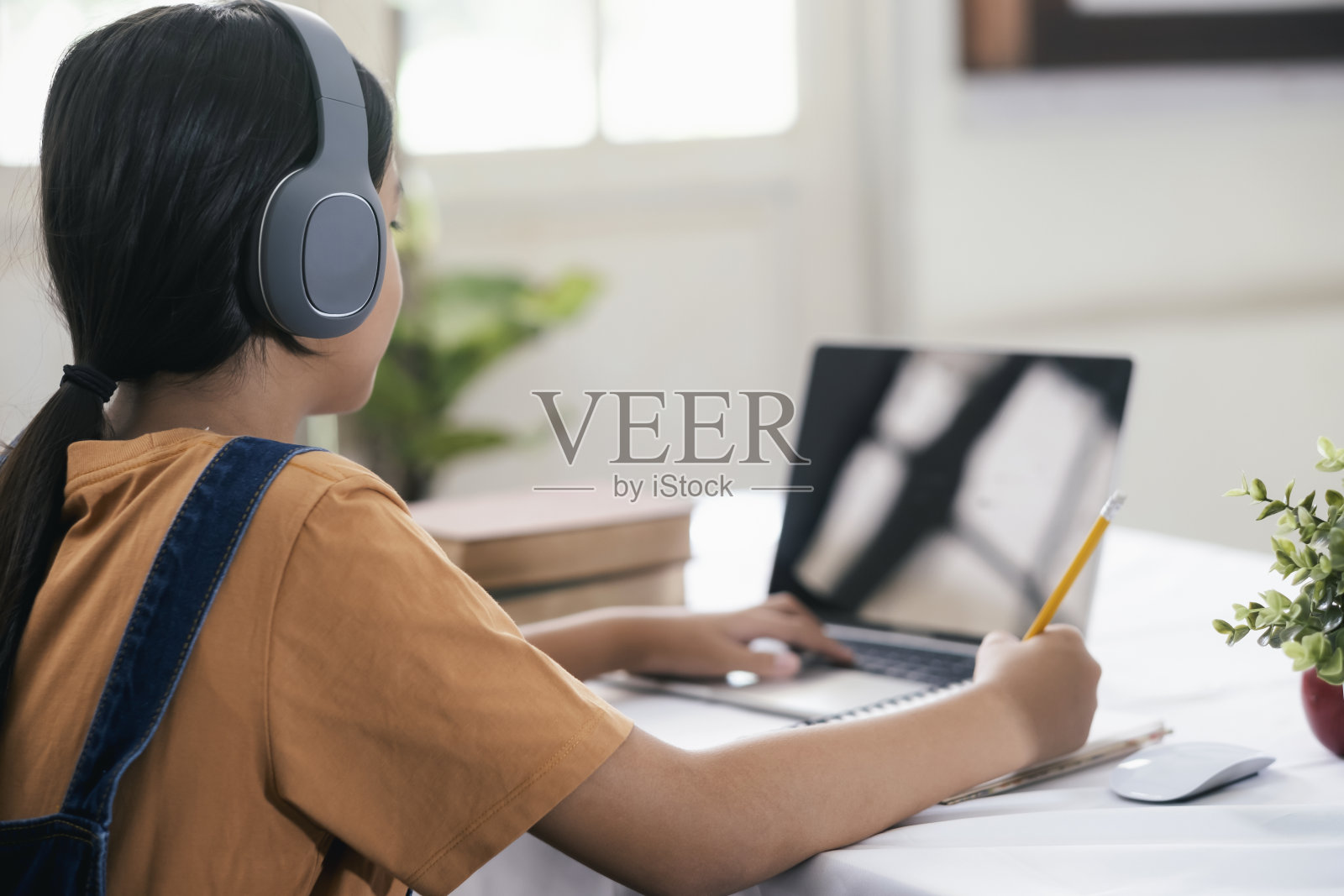 快乐的亚洲女孩在家在线学习照片摄影图片