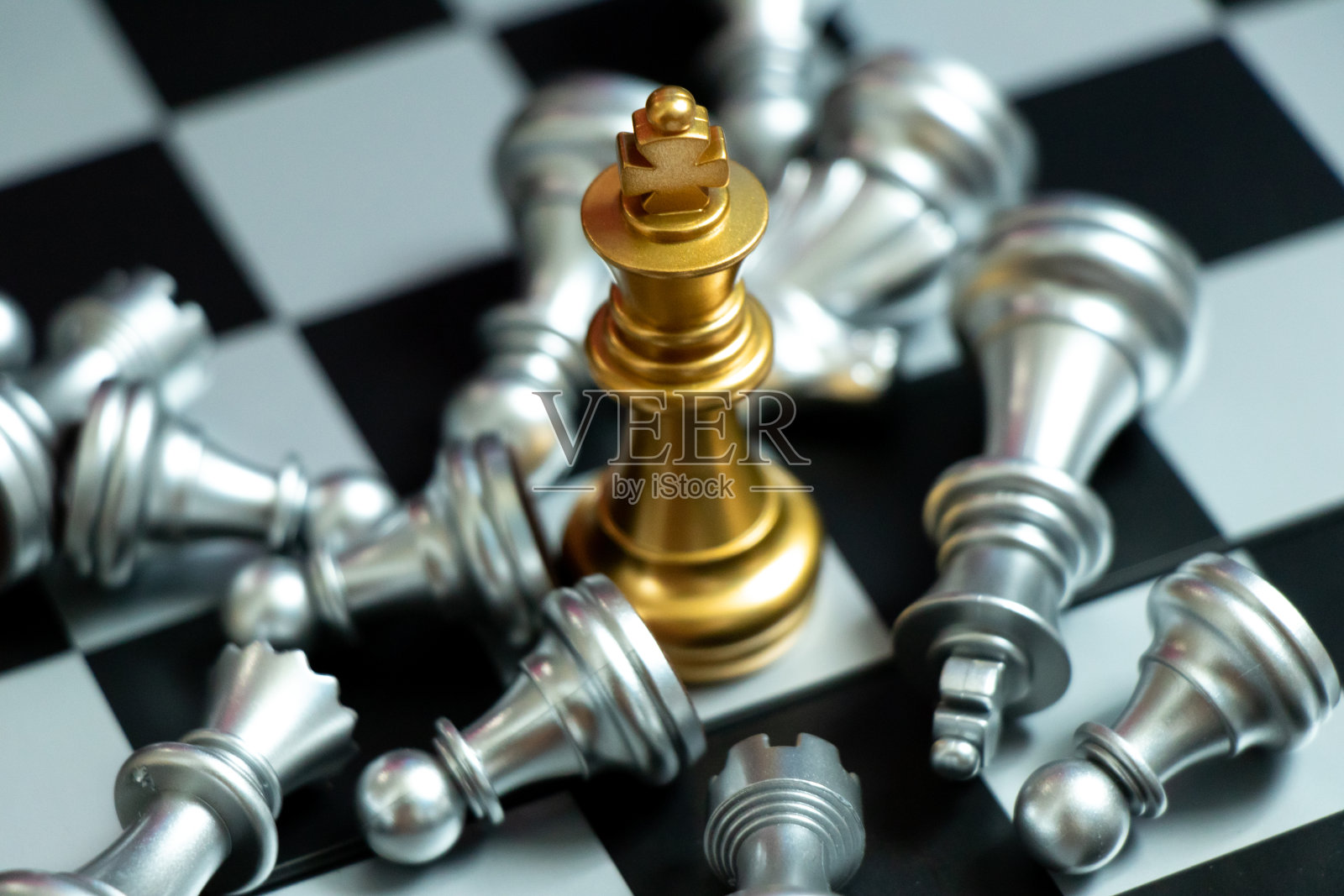 在黑色背景下，金王棋子战胜了躺着的银队照片摄影图片