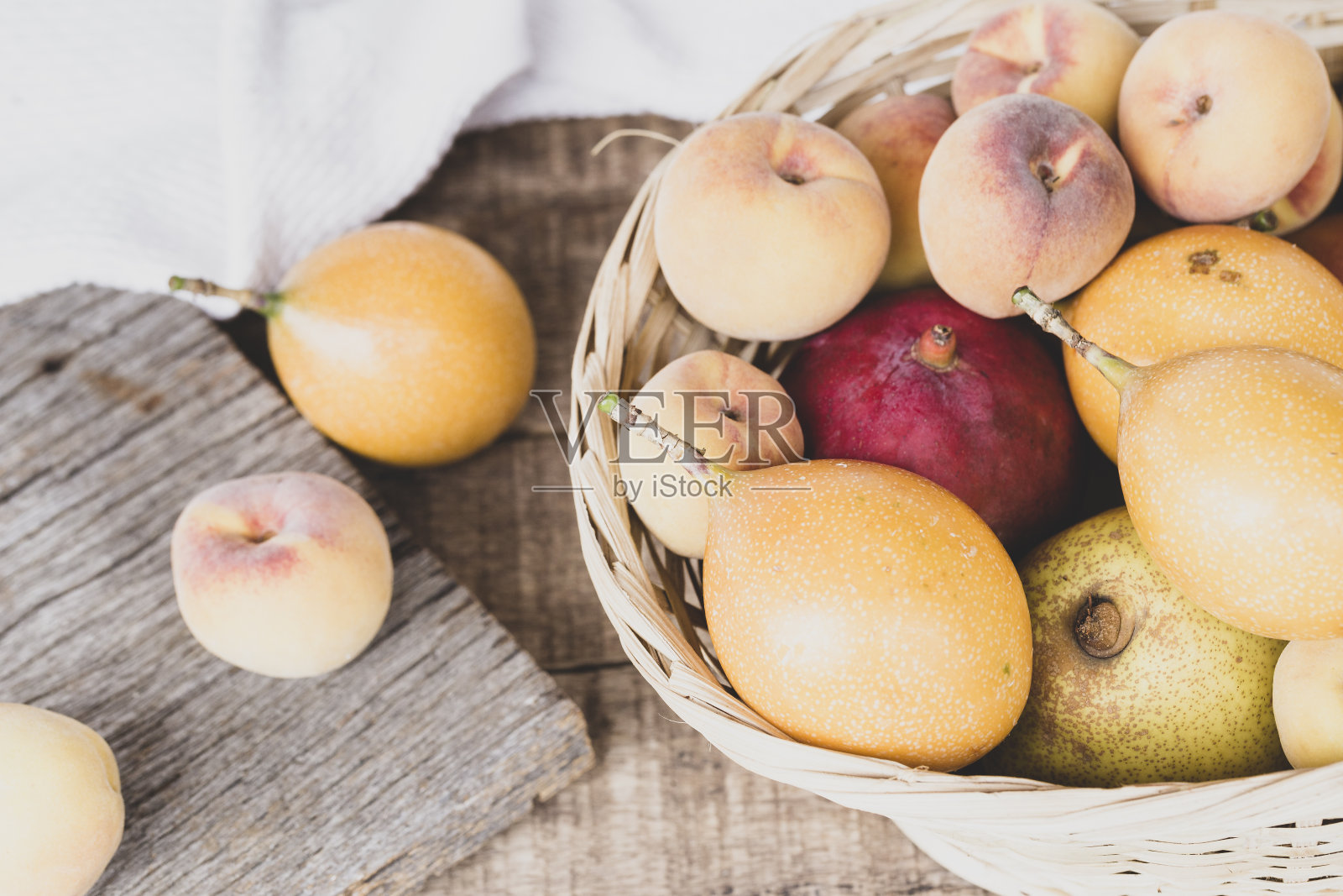 桌子上有一个篮子，里面有石榴和桃子照片摄影图片