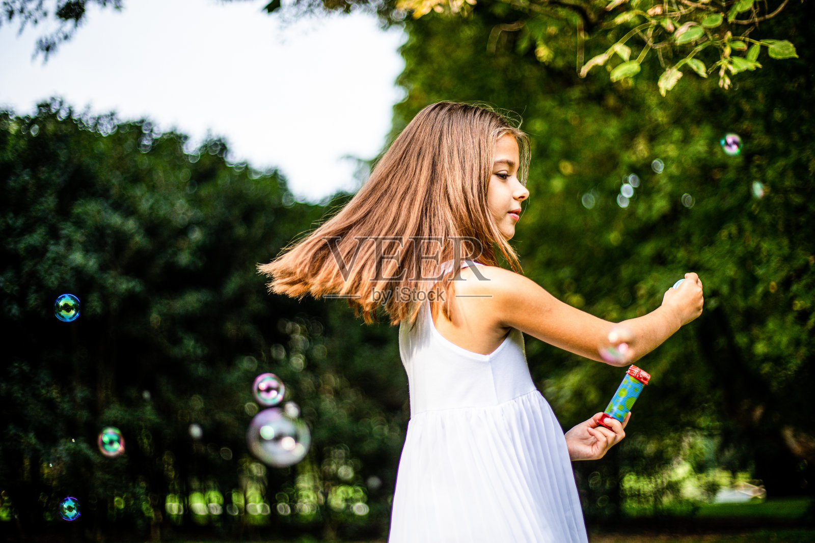 可爱的小女孩在大自然中玩肥皂泡照片摄影图片