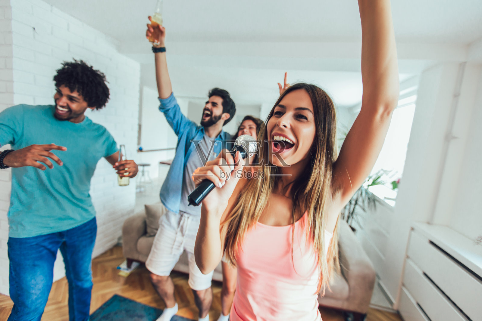 一群朋友在家里唱卡拉ok照片摄影图片