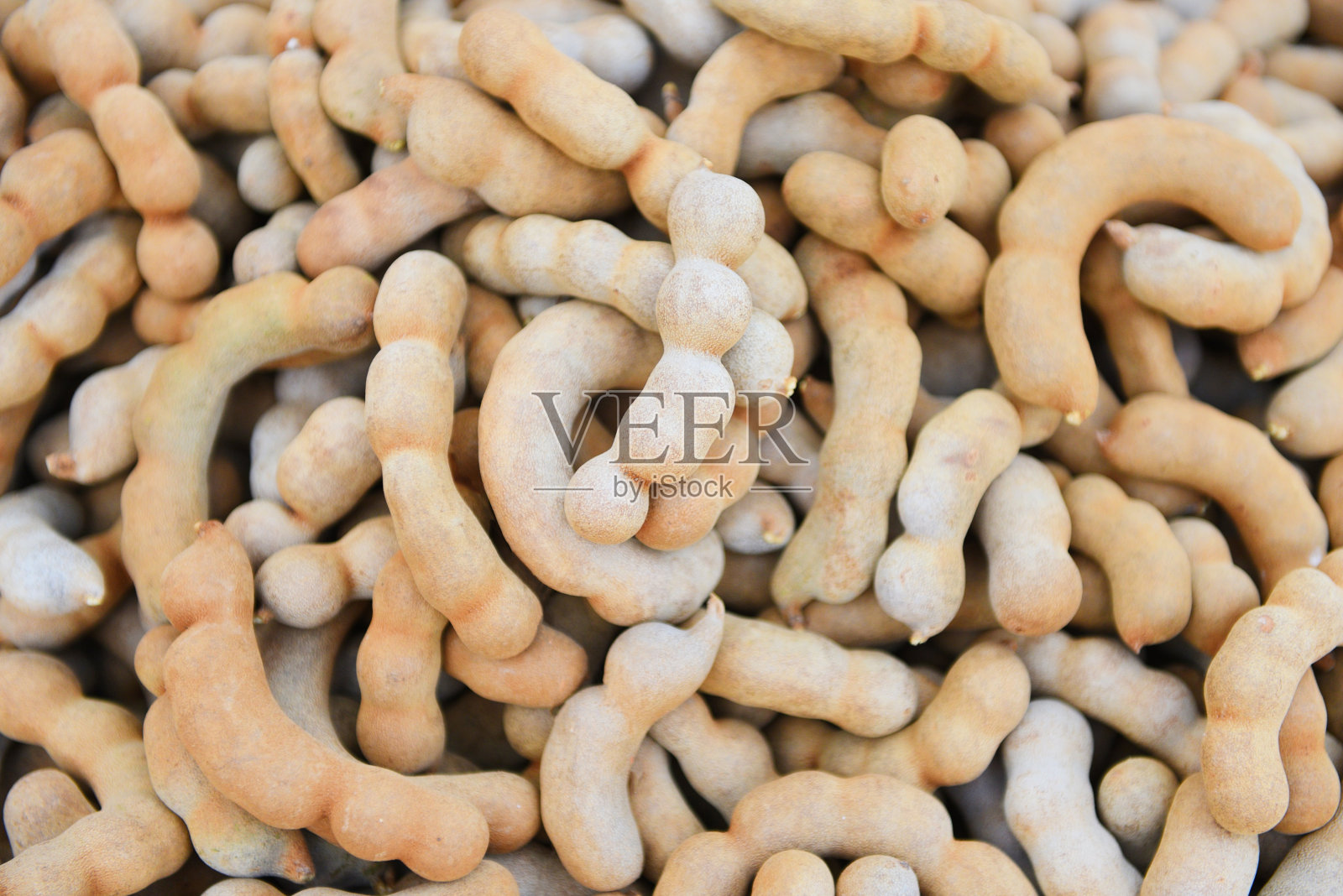 成堆的甜罗望子在市场上出售水果-新鲜罗望子纹理背景照片摄影图片