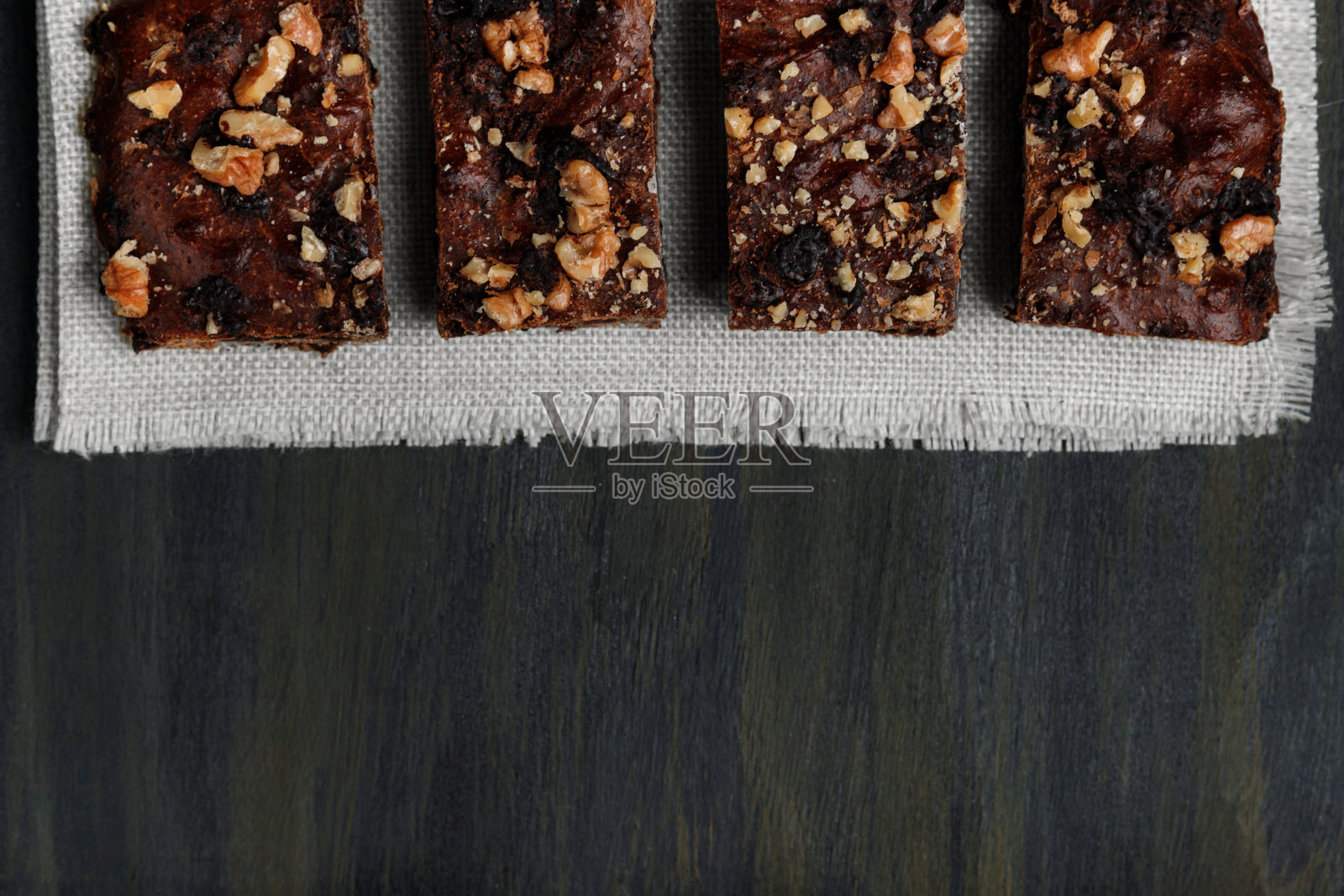 在前景顶部白色围巾上的巧克力布朗尼照片摄影图片