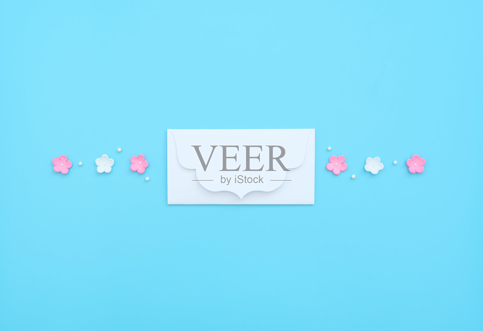 白色信封，粉红色和白色的花，泡沫和珠子在蓝色的背景。母亲节，情人节，婚礼，生日概念。问候卡或请帖。平铺与拷贝空间。照片摄影图片