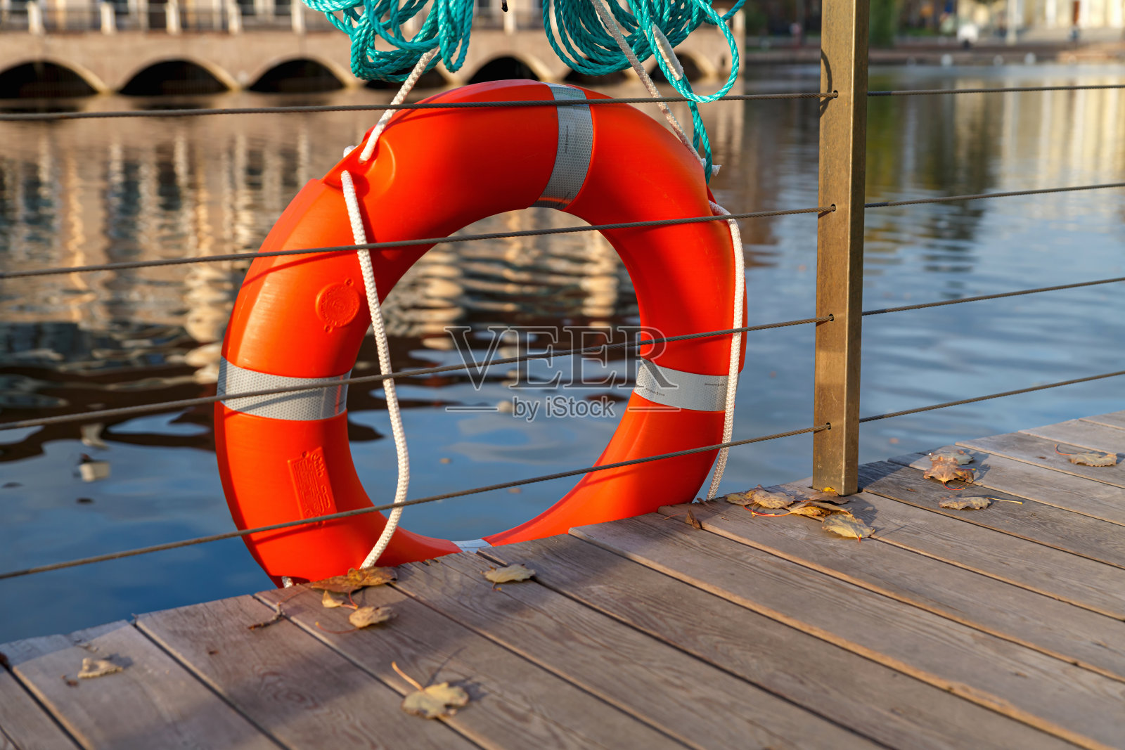 湖岸围栏上的橙色救生圈。救生圈来救那些落水的人。照片摄影图片