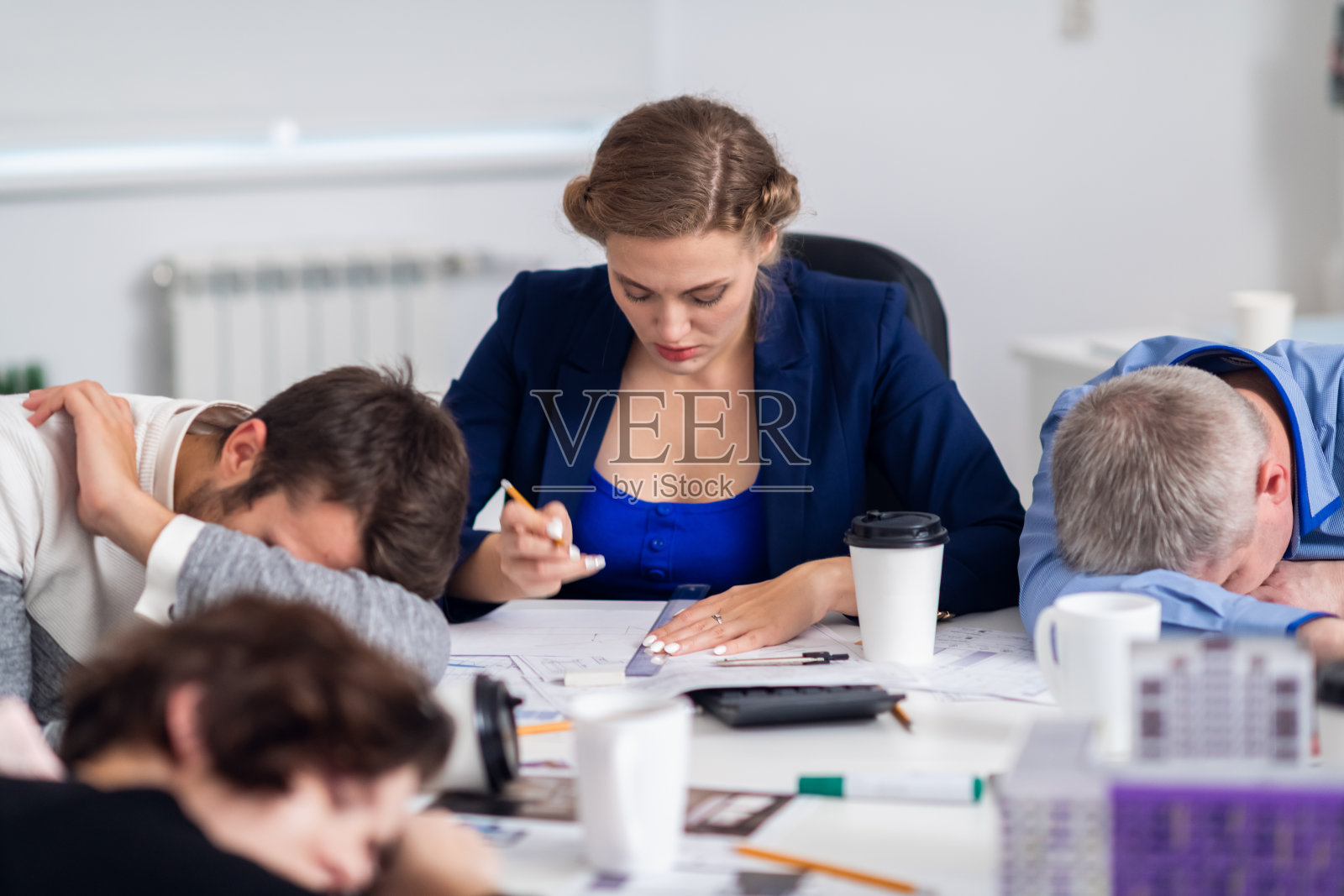 疲惫的办公室工作人员在工作场所休息，同时拥有照片摄影图片