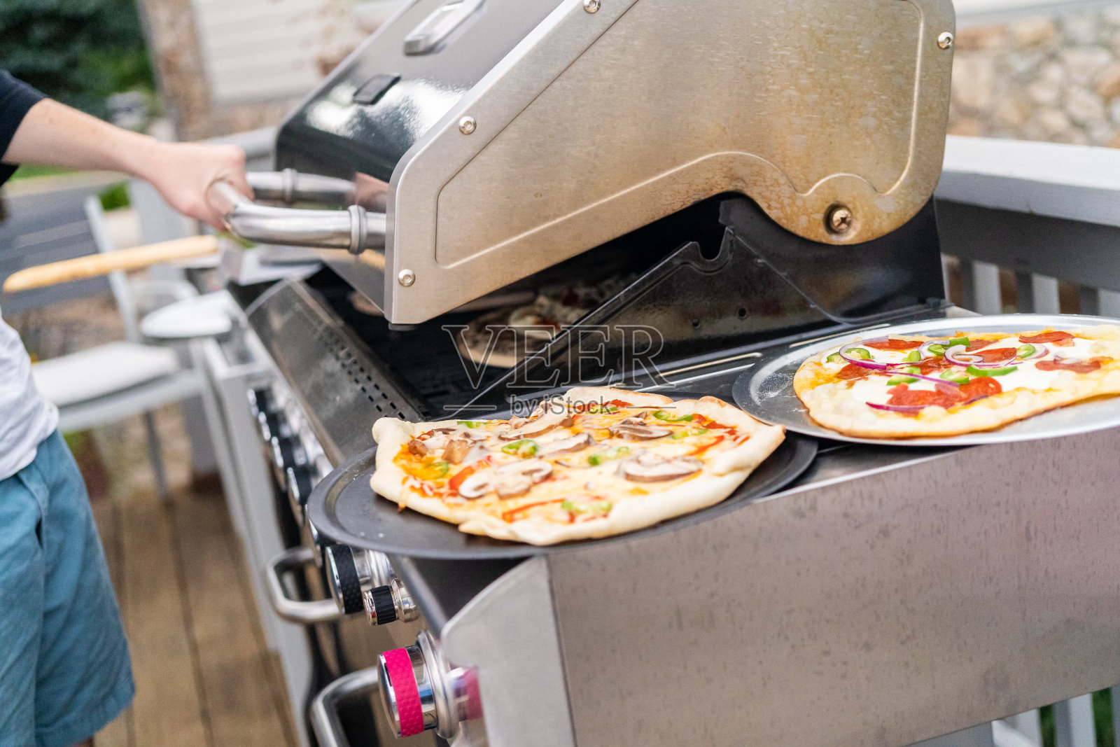 在室外燃气烤架上准备单独的烤披萨。照片摄影图片