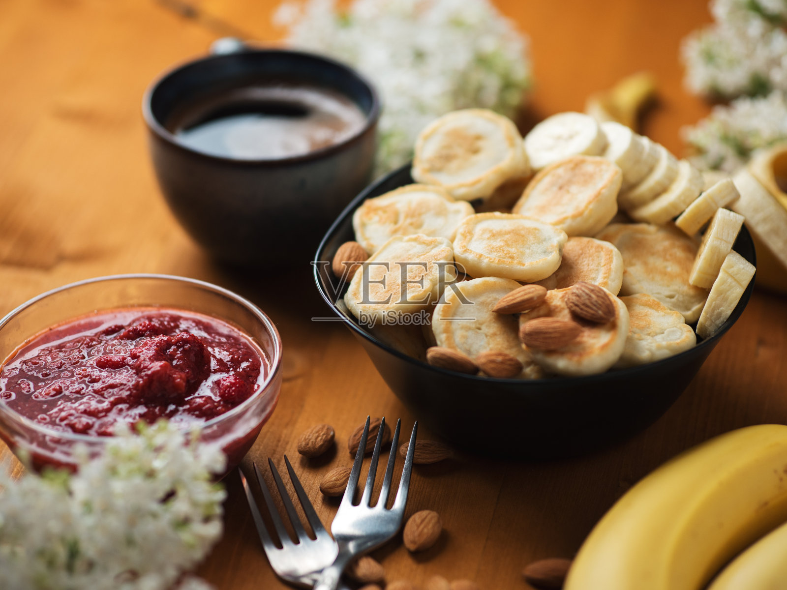 木桌上放着草莓酱、香蕉和一杯咖啡照片摄影图片