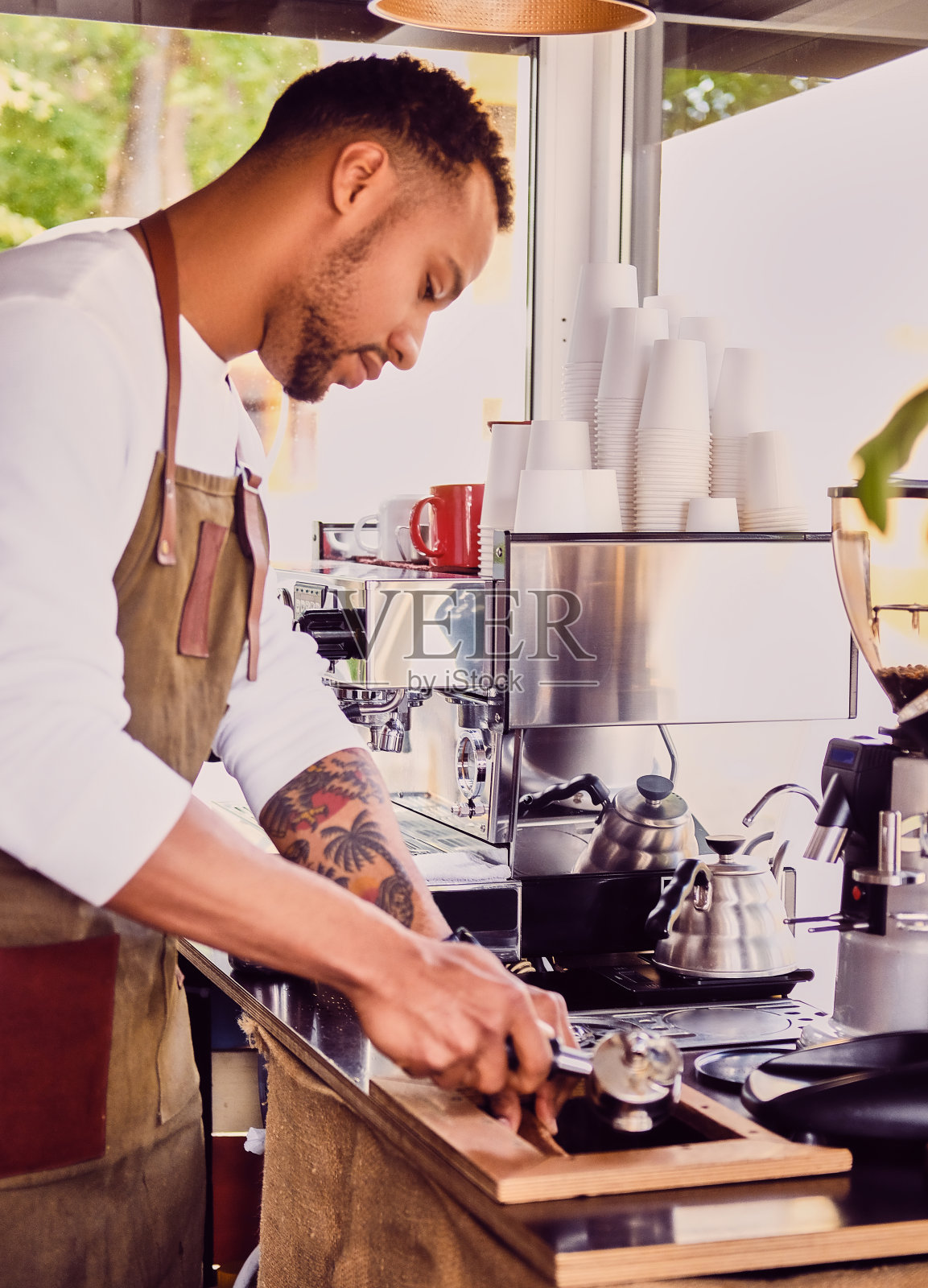 一个正在餐厅倒咖啡的男人。照片摄影图片