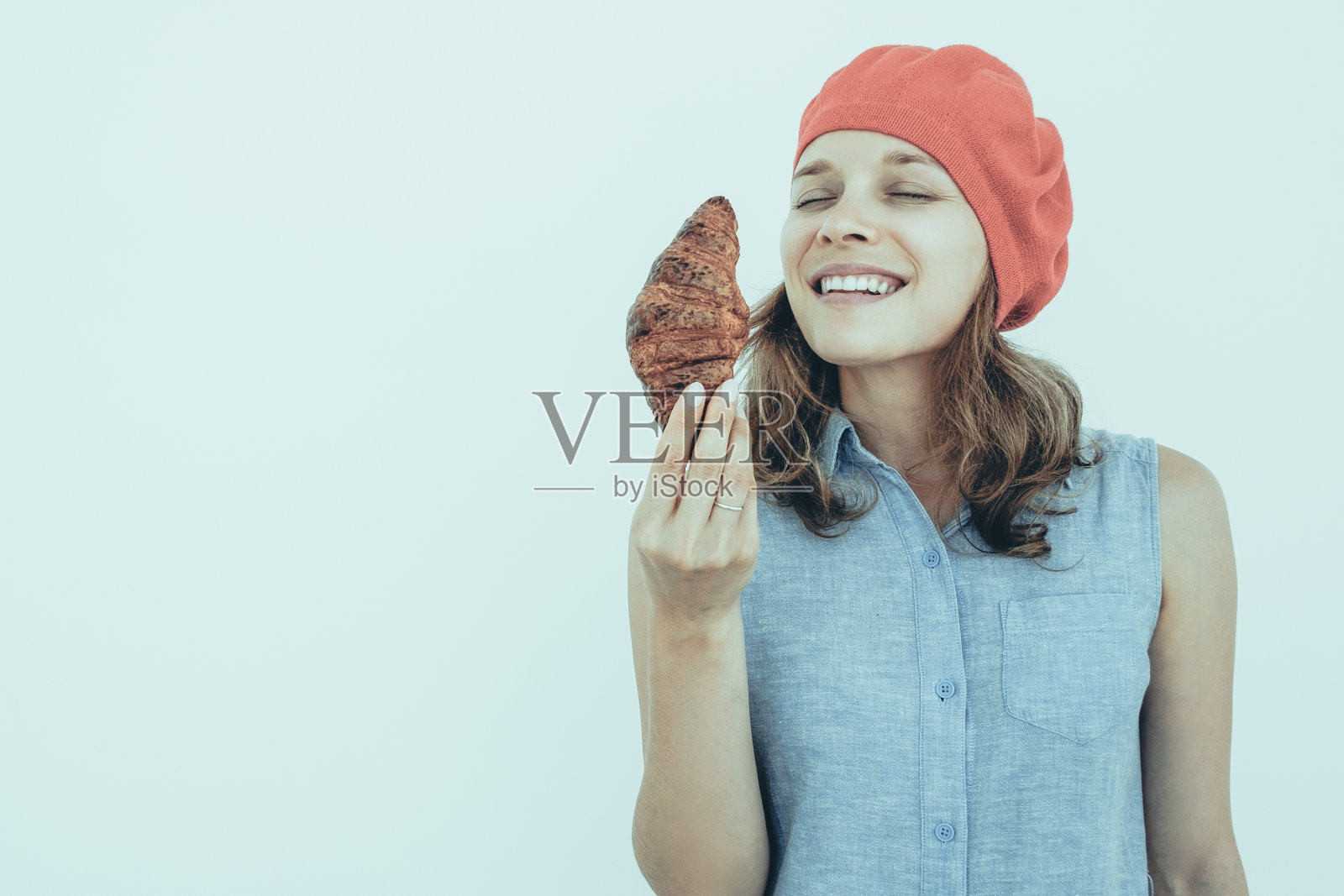 微笑漂亮女人闻美味羊角面包照片摄影图片