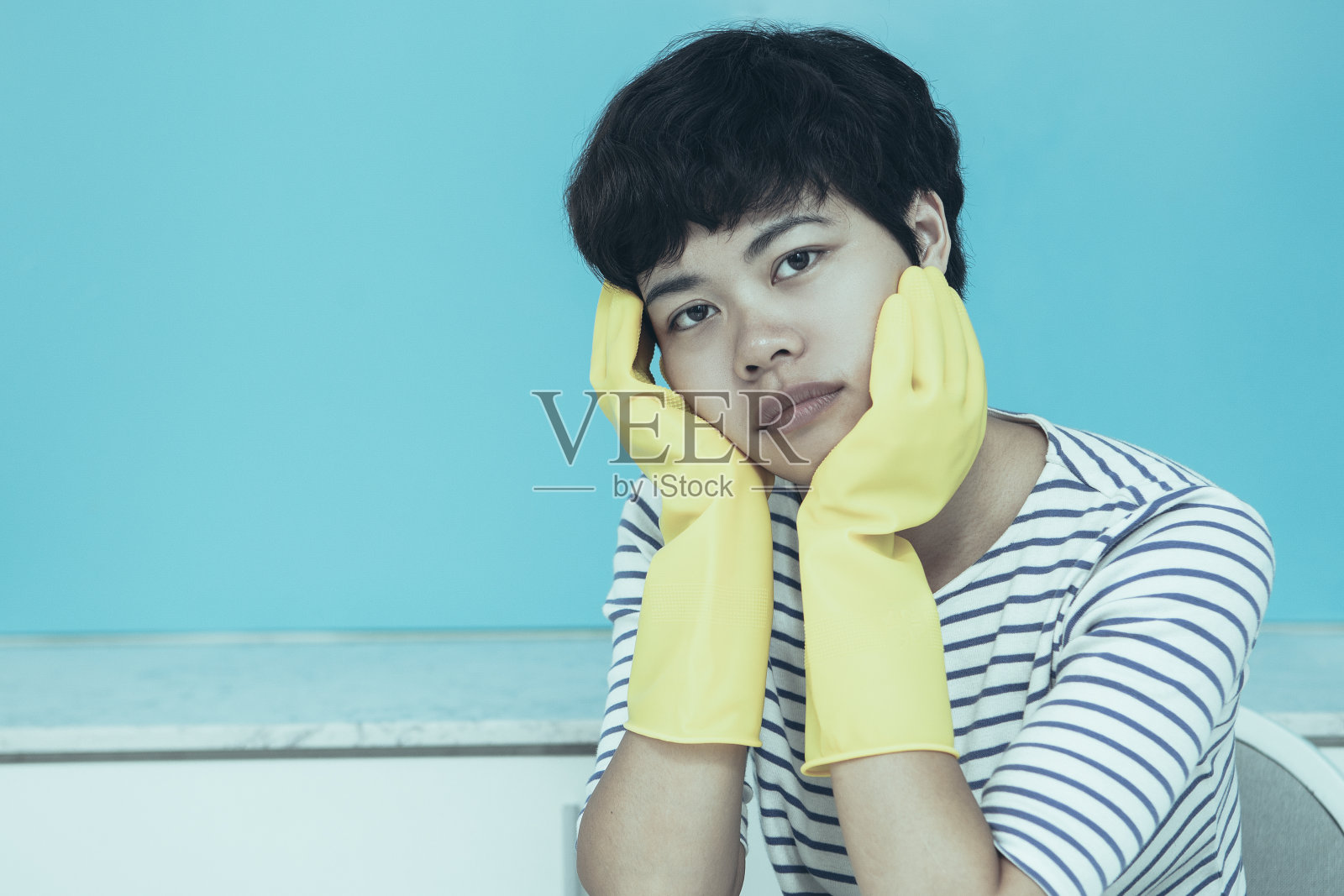 厨房里戴着防护手套的疲惫主妇照片摄影图片