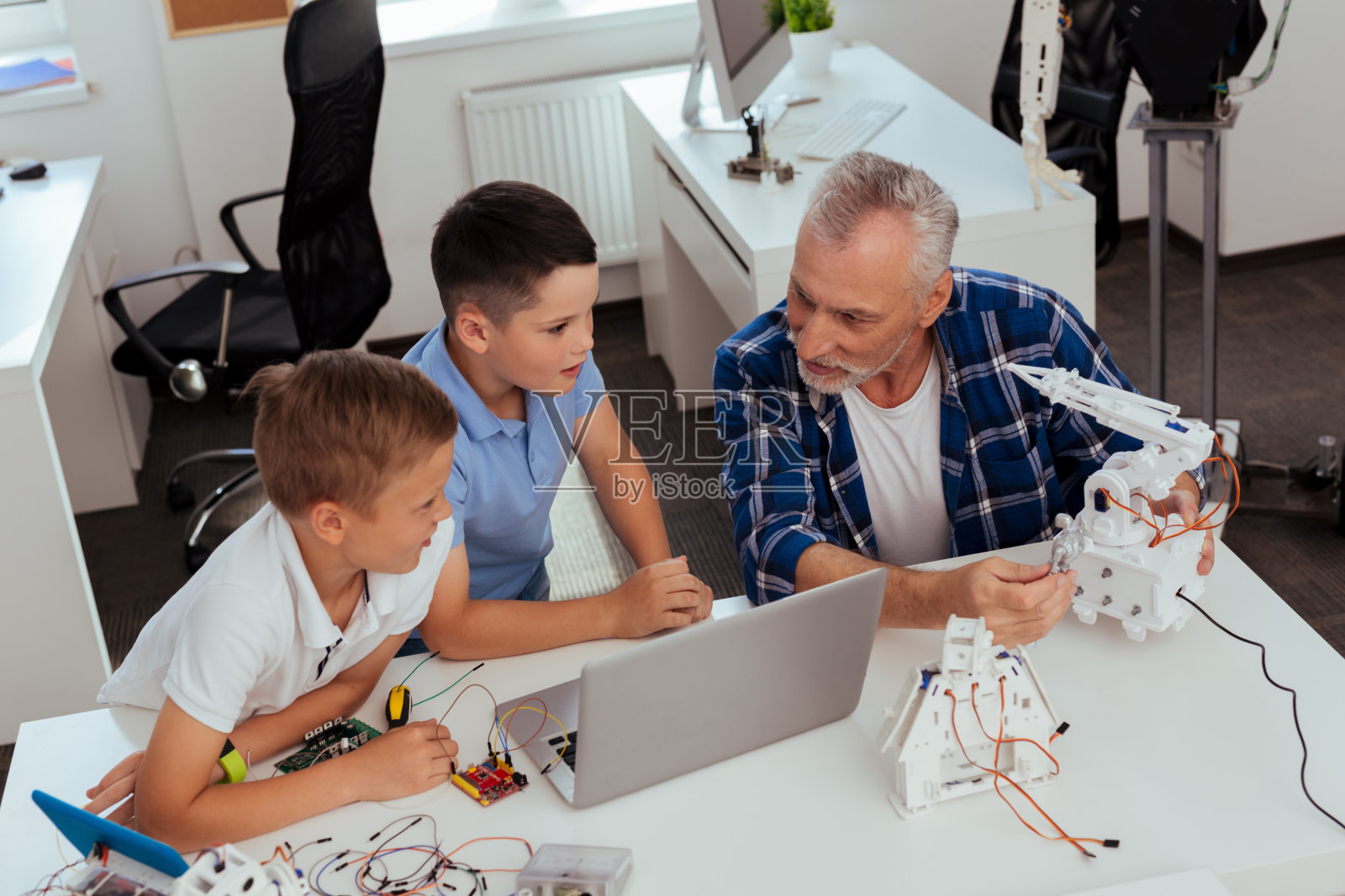 坐在笔记本电脑前的快乐乐观的男孩们照片摄影图片